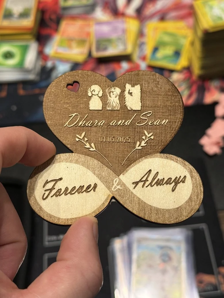Wooden keepsake with engraved names Dhara and Sean, a date of 01.05.2025, and the words Forever & Always, with a small heart and dog illustrations at the top.