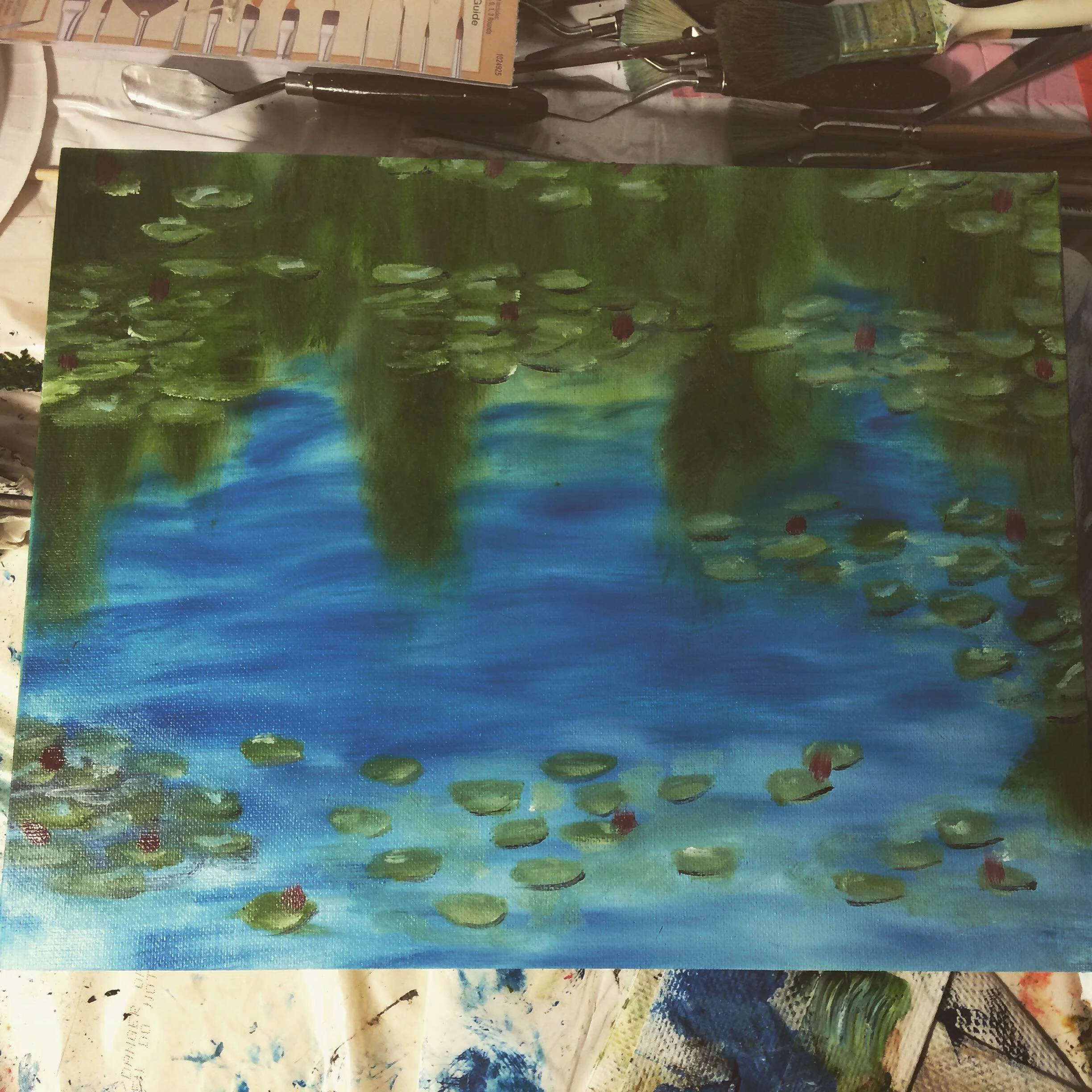 A painting of a pond with lily pads and water reflections, with trees and greenery in the background.