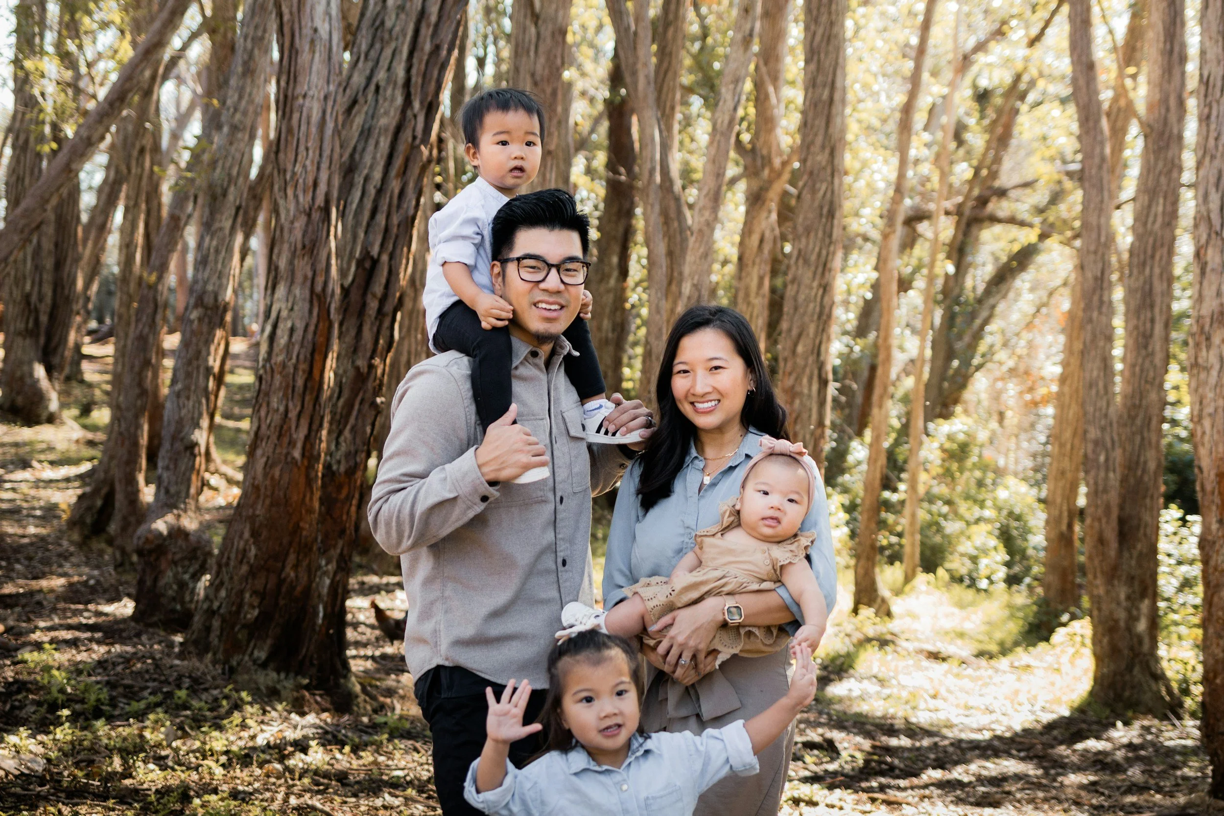 A loving Asian couple with their growing family, smiling together, capturing a warm moment of connection and unity.
