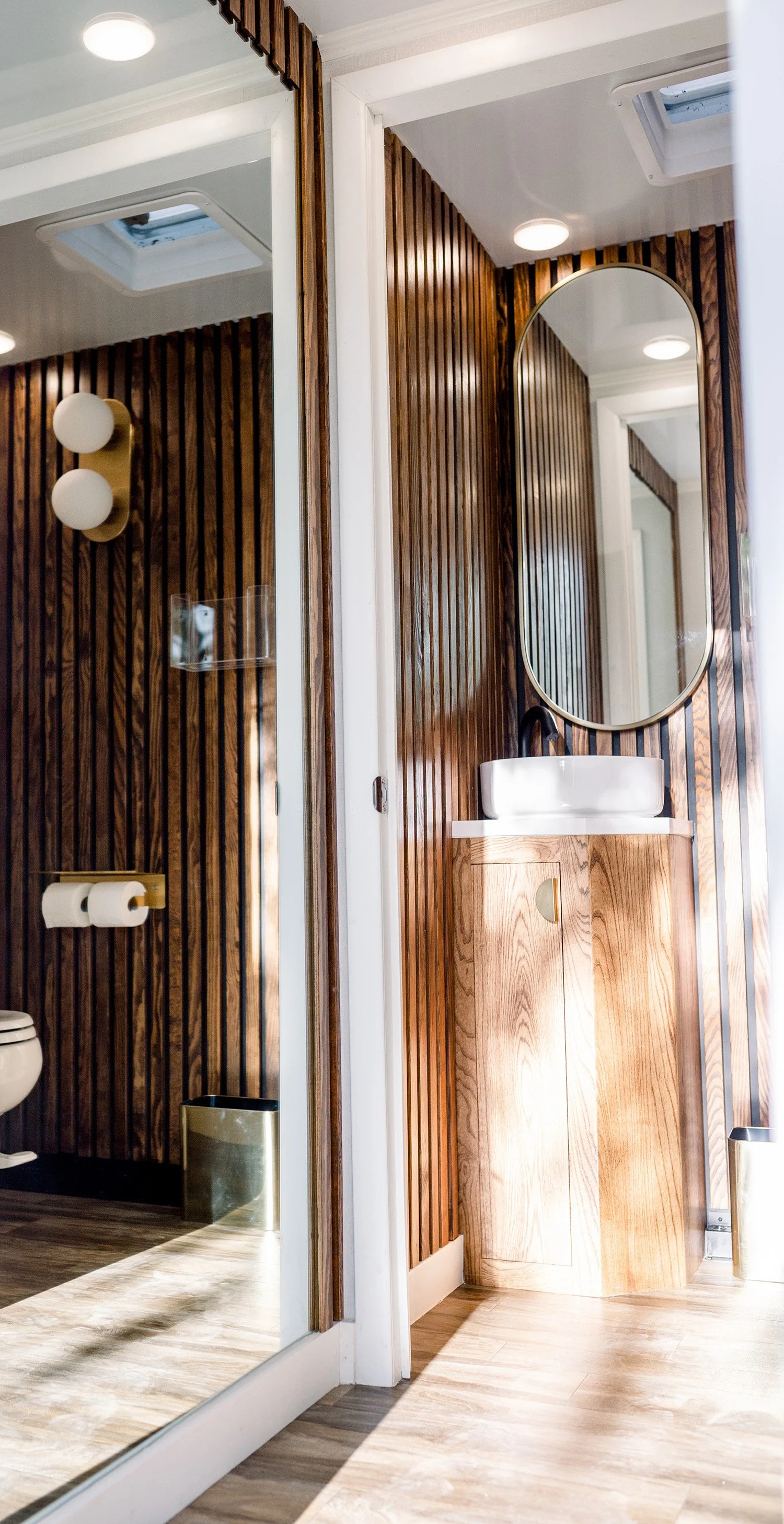 interior of pretty powder room with wood accents and mirror