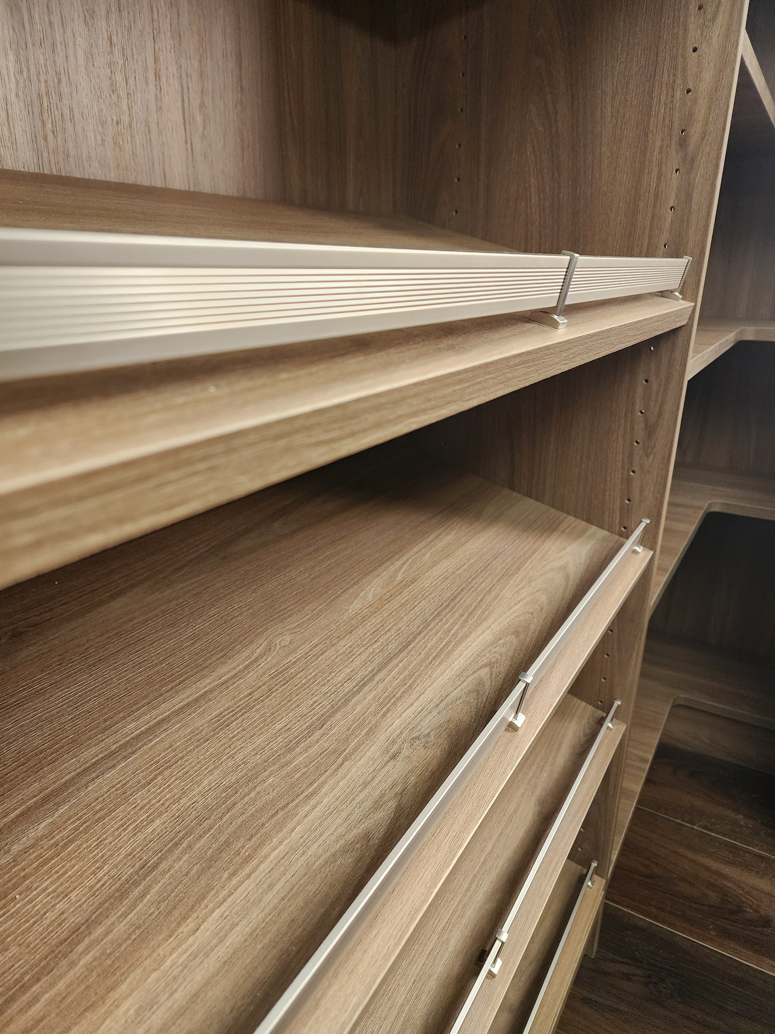 Close up of Shoe rail on a slanted shoe shelf