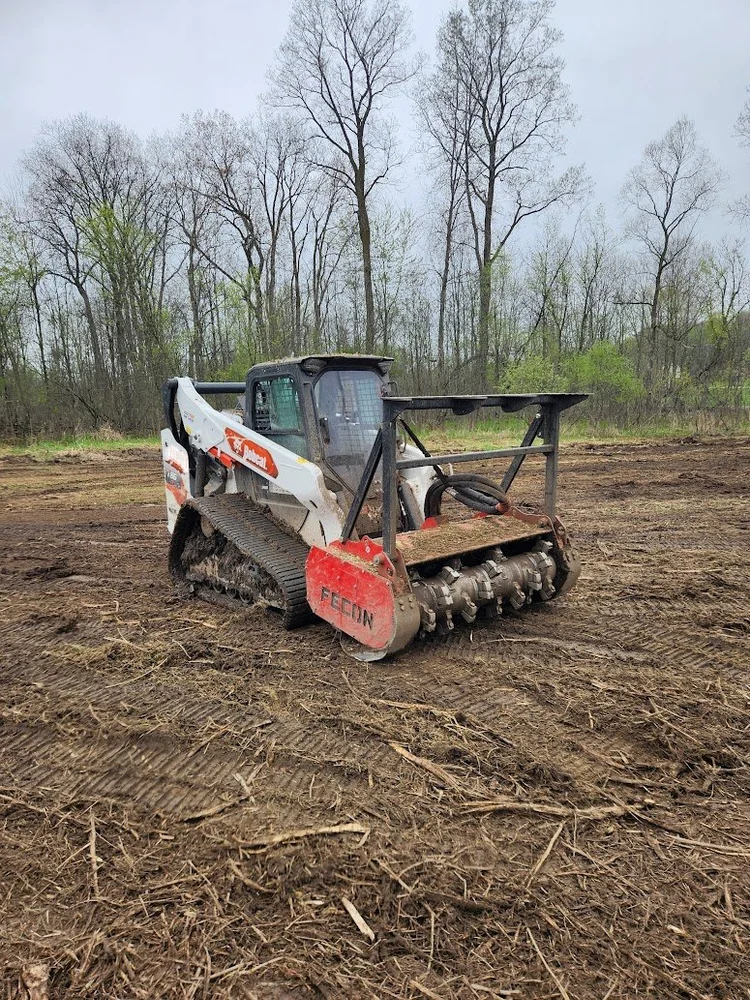 Skid steer forestry mulcher clearing overgrown land in Michigan