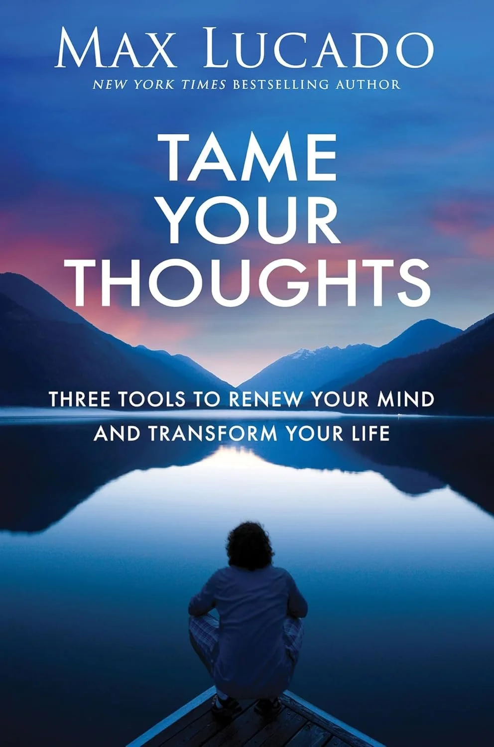 Book cover titled 'Tame Your Thoughts' by Max Lucado, showing a person sitting by a lake with mountains in the background during sunset.