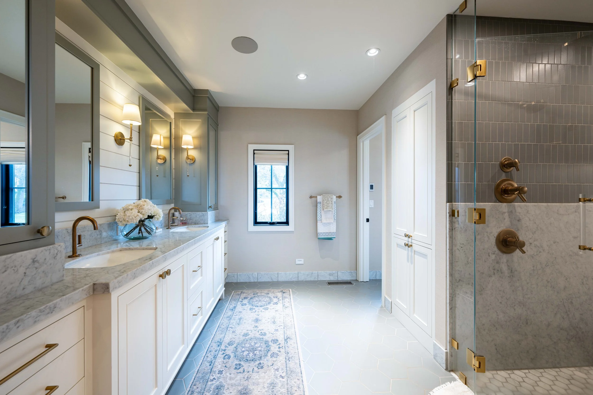 Primary bathroom with dual vanity, glass shower, and soft neutral finishes
