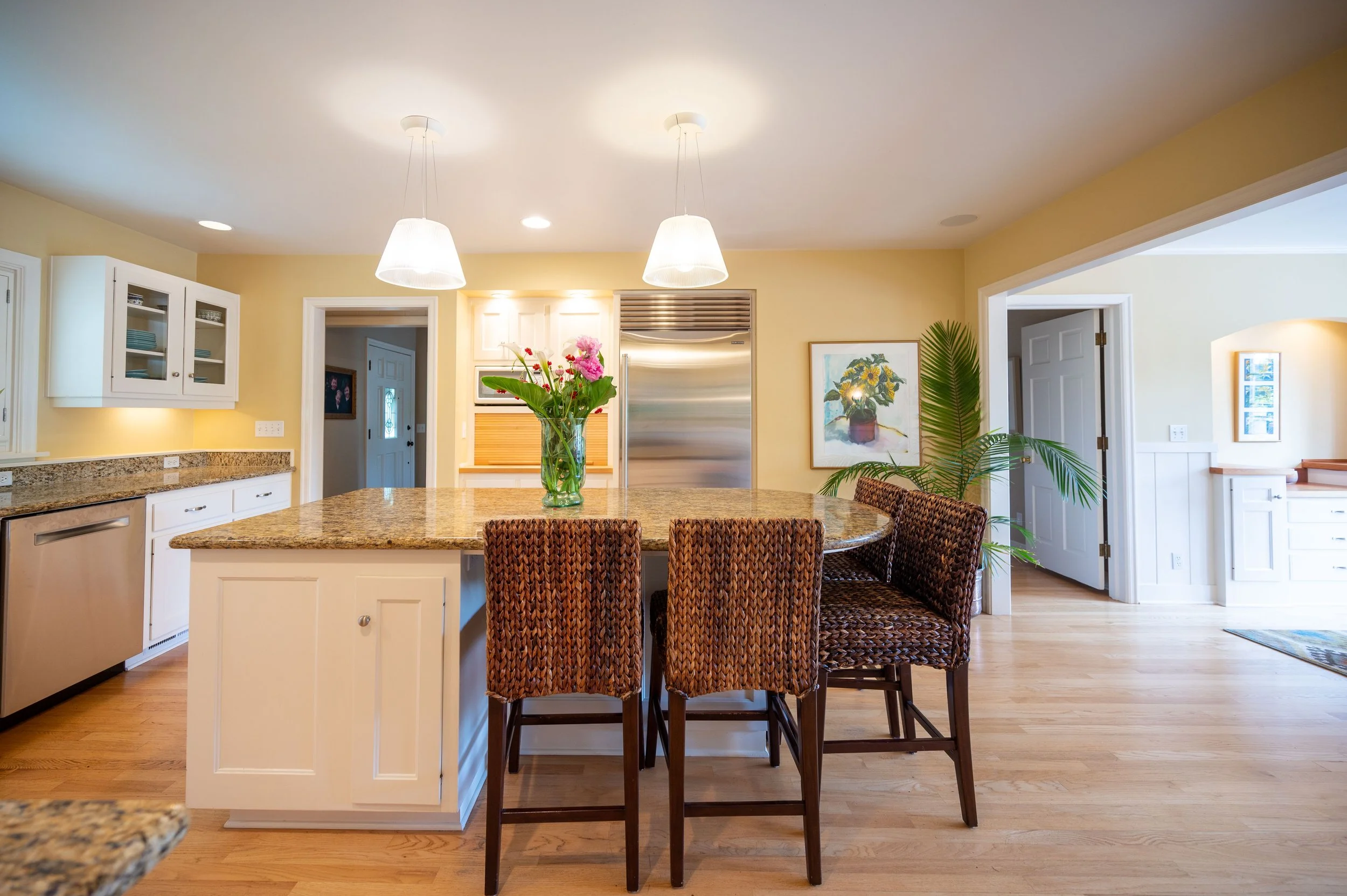 Kitchen island with bar seating, pendant lights, and granite countertops