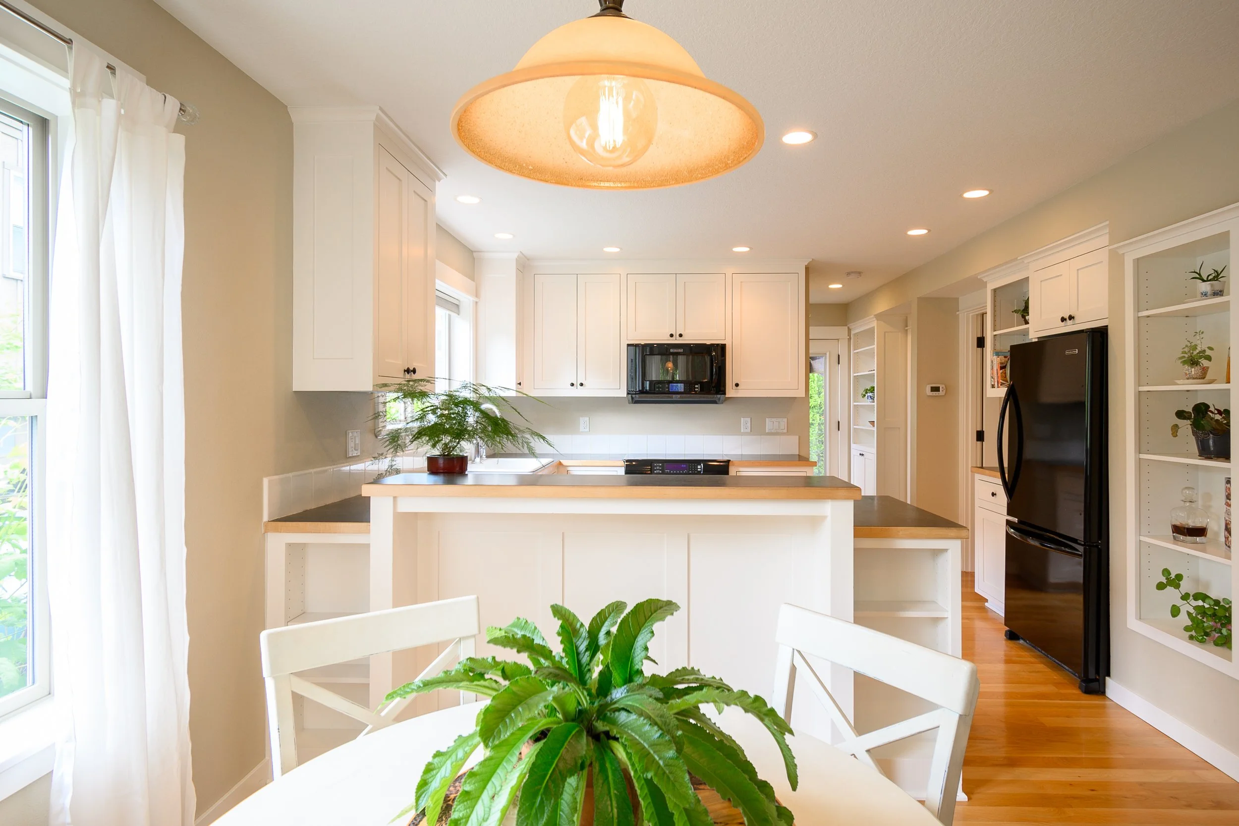 Bright kitchen with white cabinetry, island, and pendant lighting