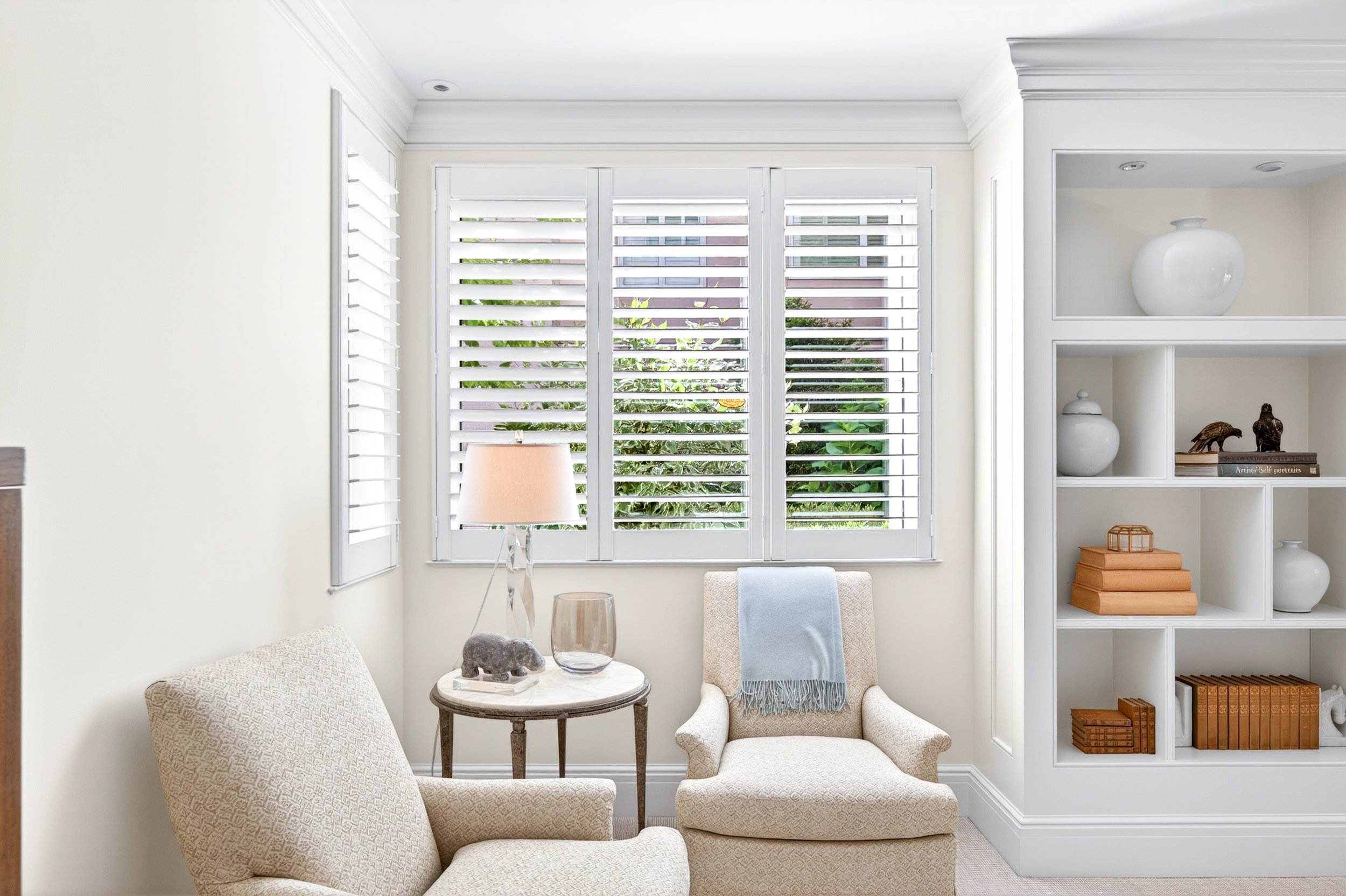 Living room with white chairs and book shelf