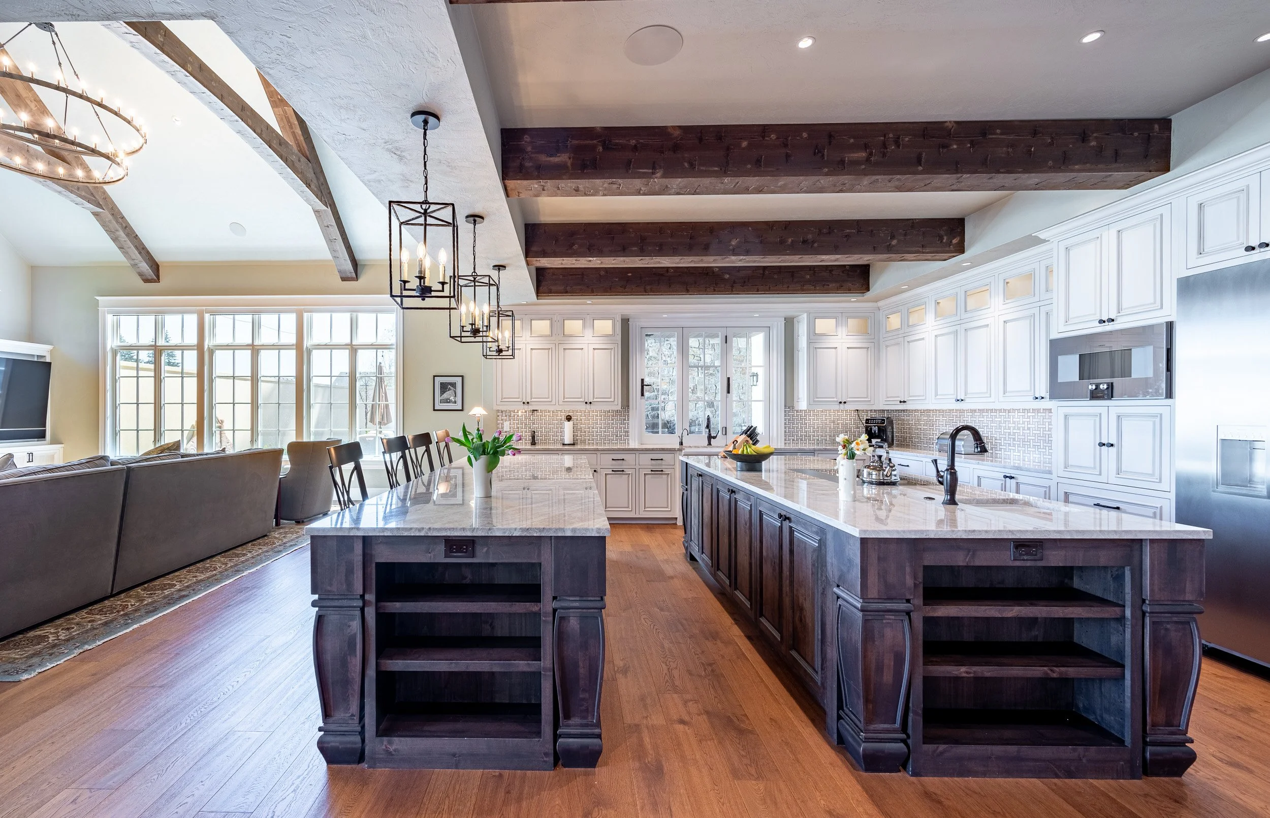 Kitchen with large island, exposed wood ceiling beams, and custom cabinetry