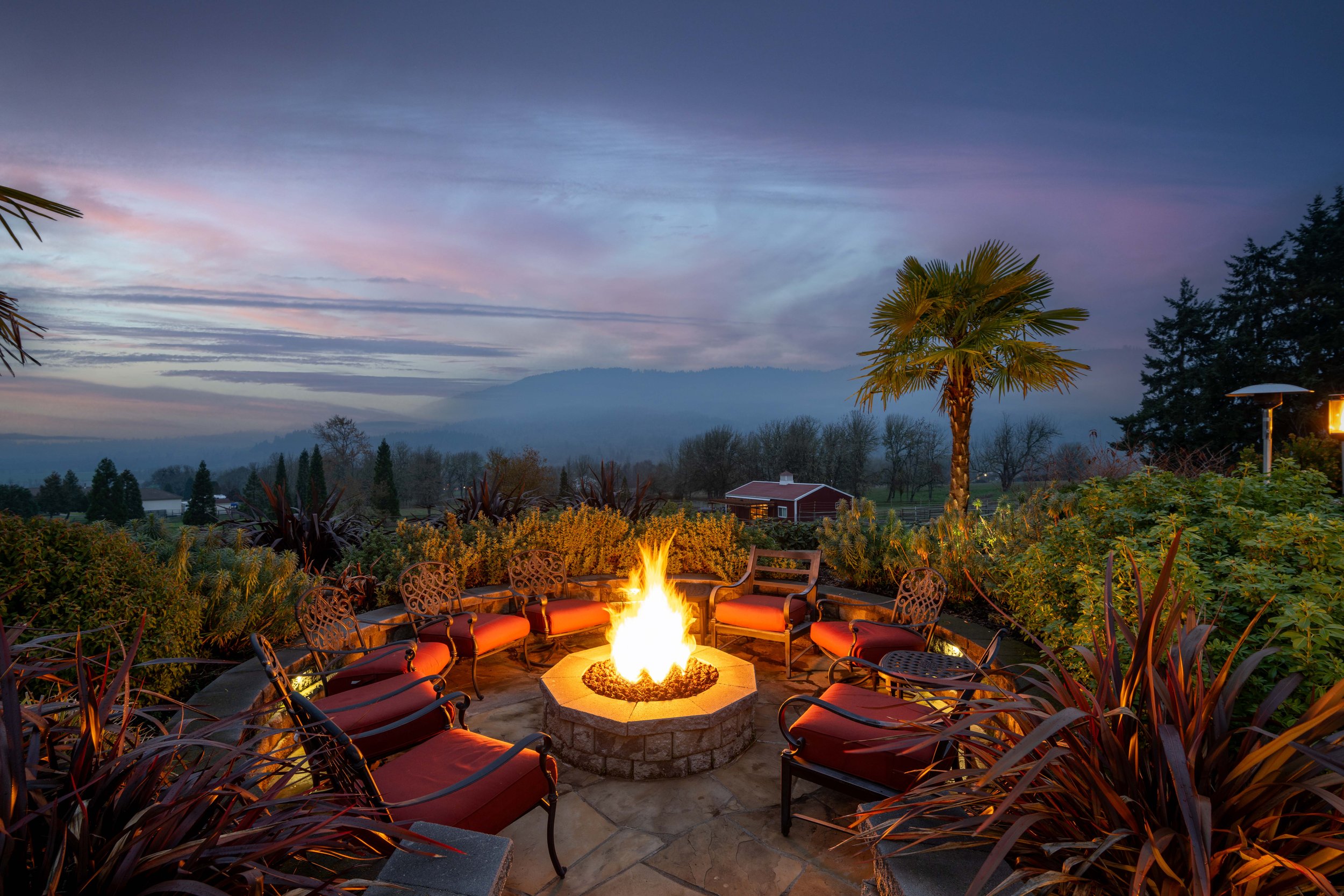 Twilight photo of a backyard patio firepit in Portland, Oregon with a beautiful sunset