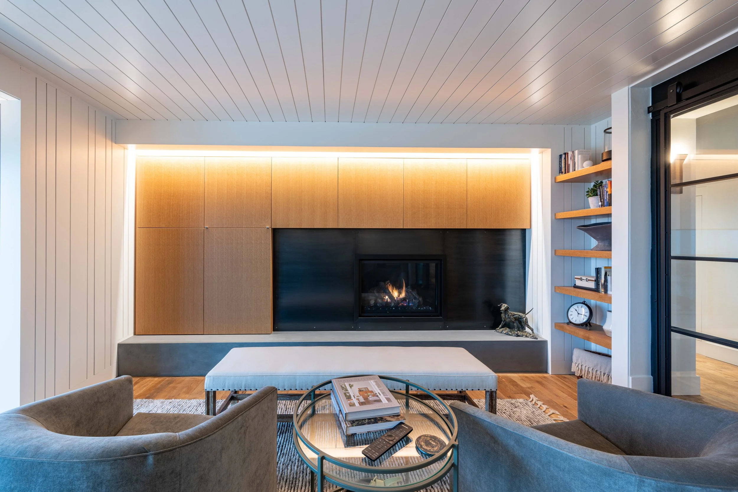 Office with modern fireplace, built-in shelving, and warm accent lighting