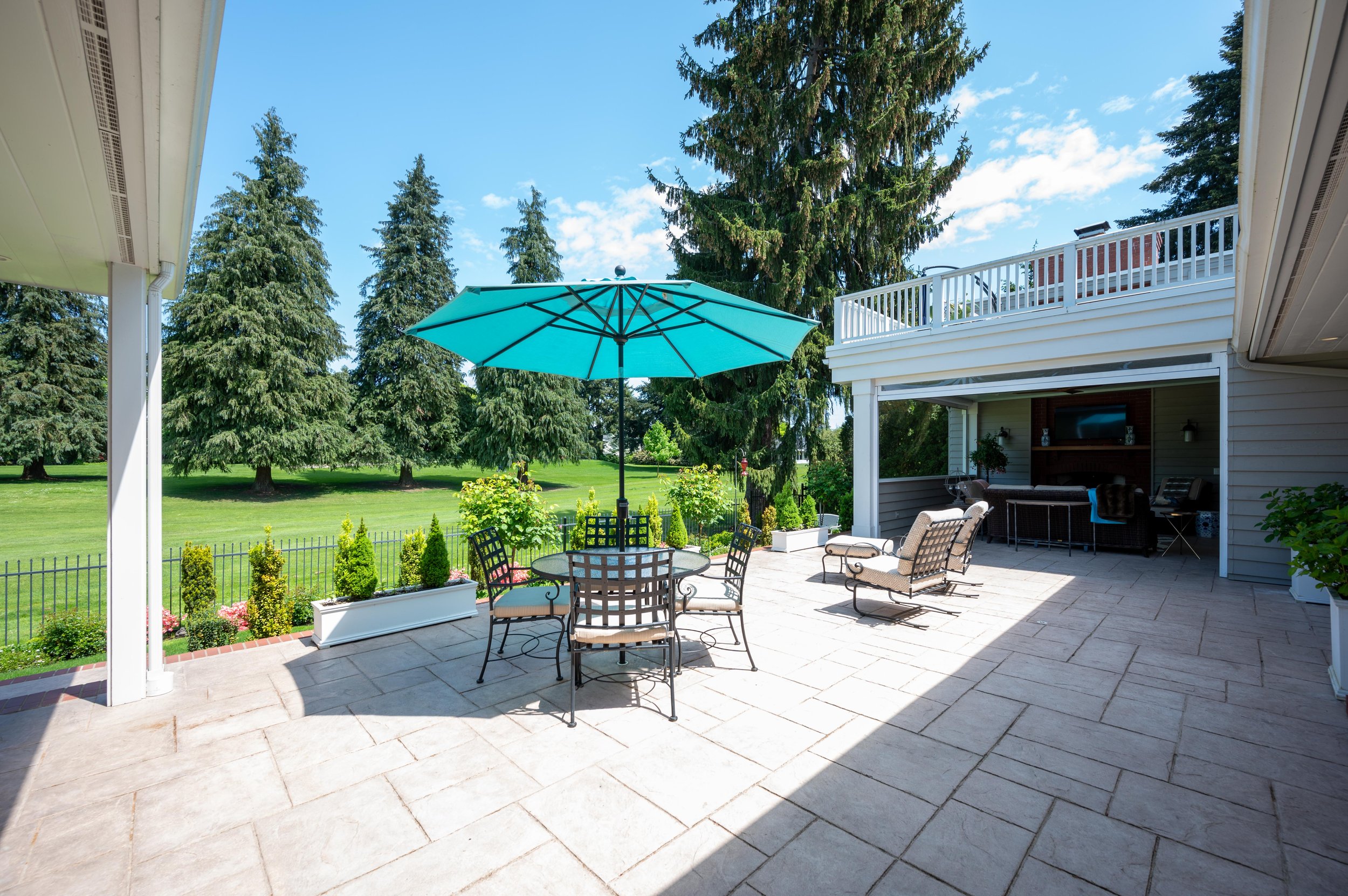 Backyard patio with outdoor dining set and green lawn