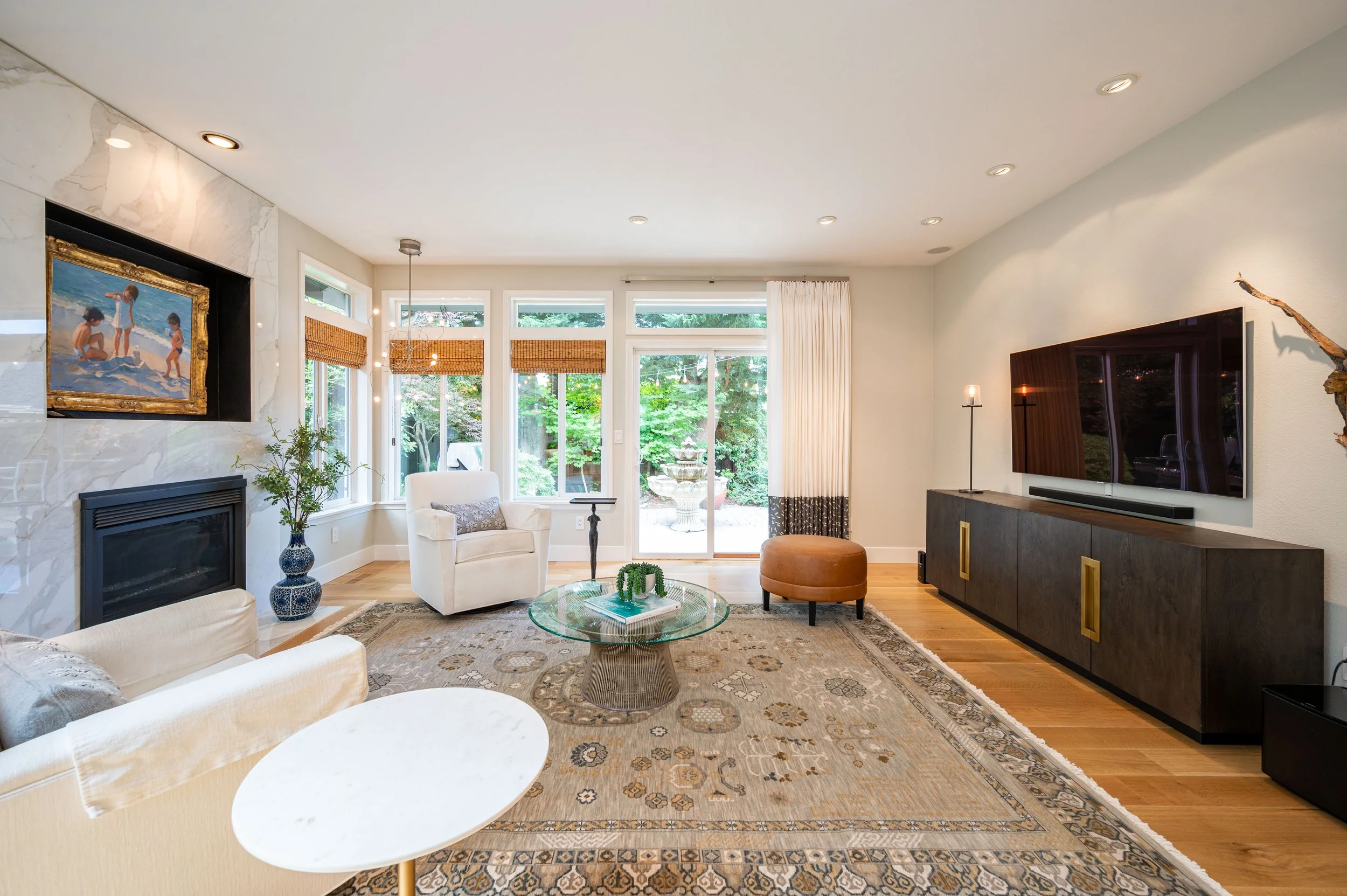 Bright living room with large windows, area rug, and modern seating arrangement