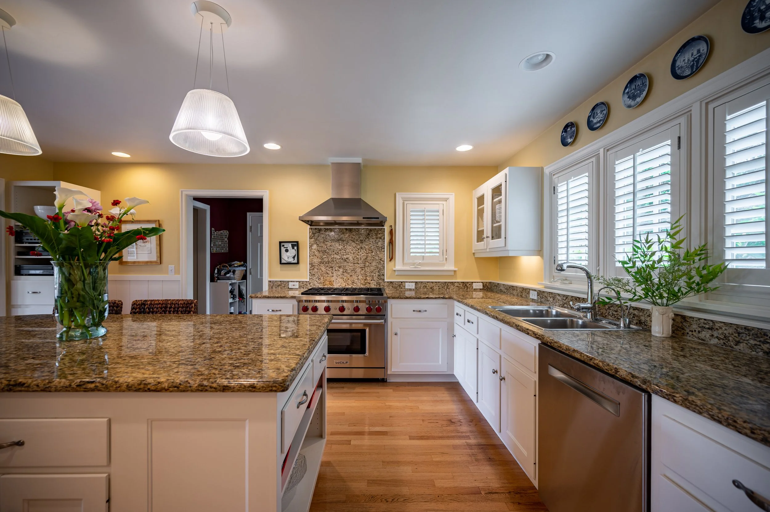 Bright kitchen with white cabinetry, stainless appliances, and wood floors