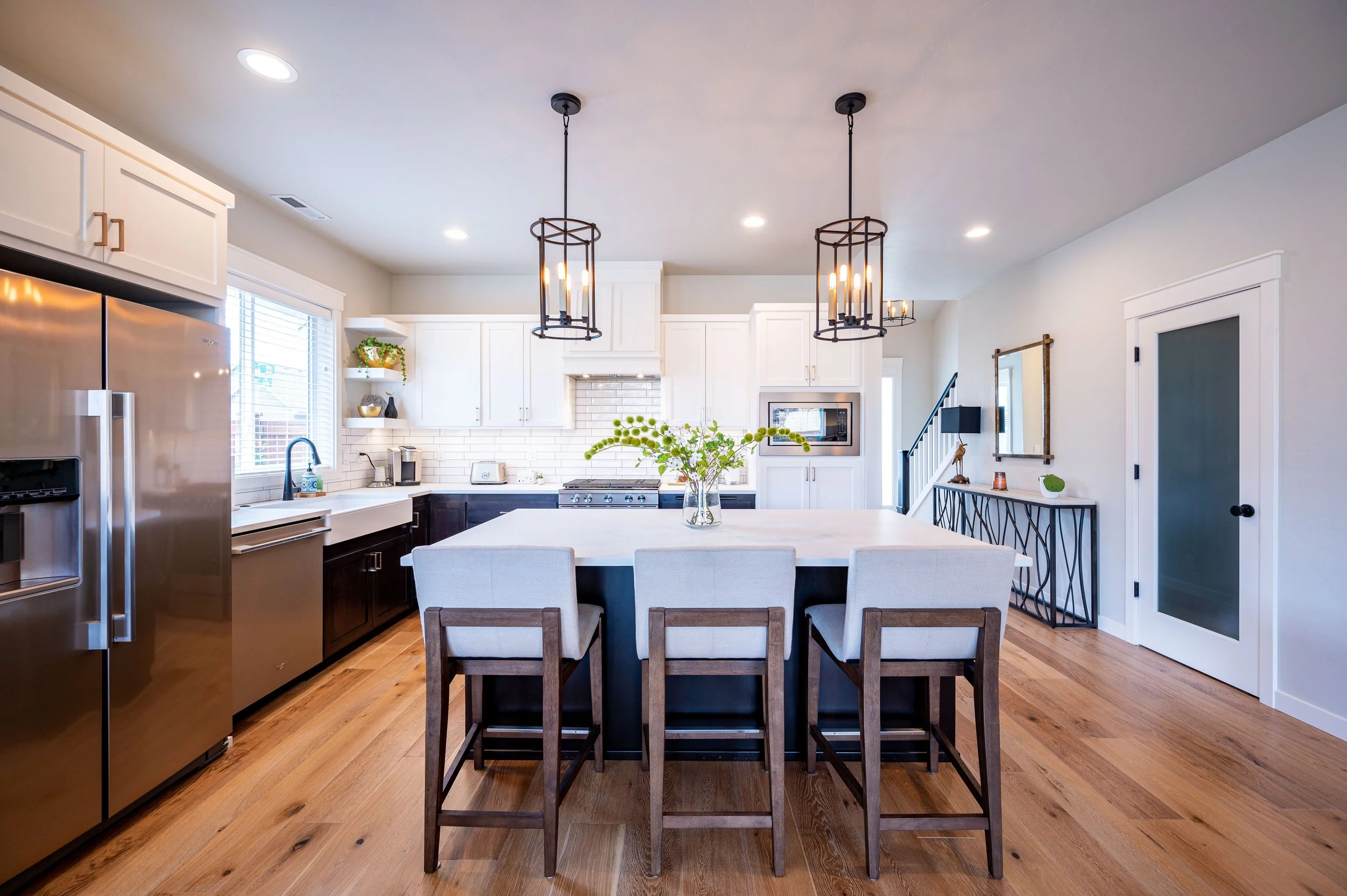 Contemporary kitchen with island, stainless steel appliances, and modern light fixtures