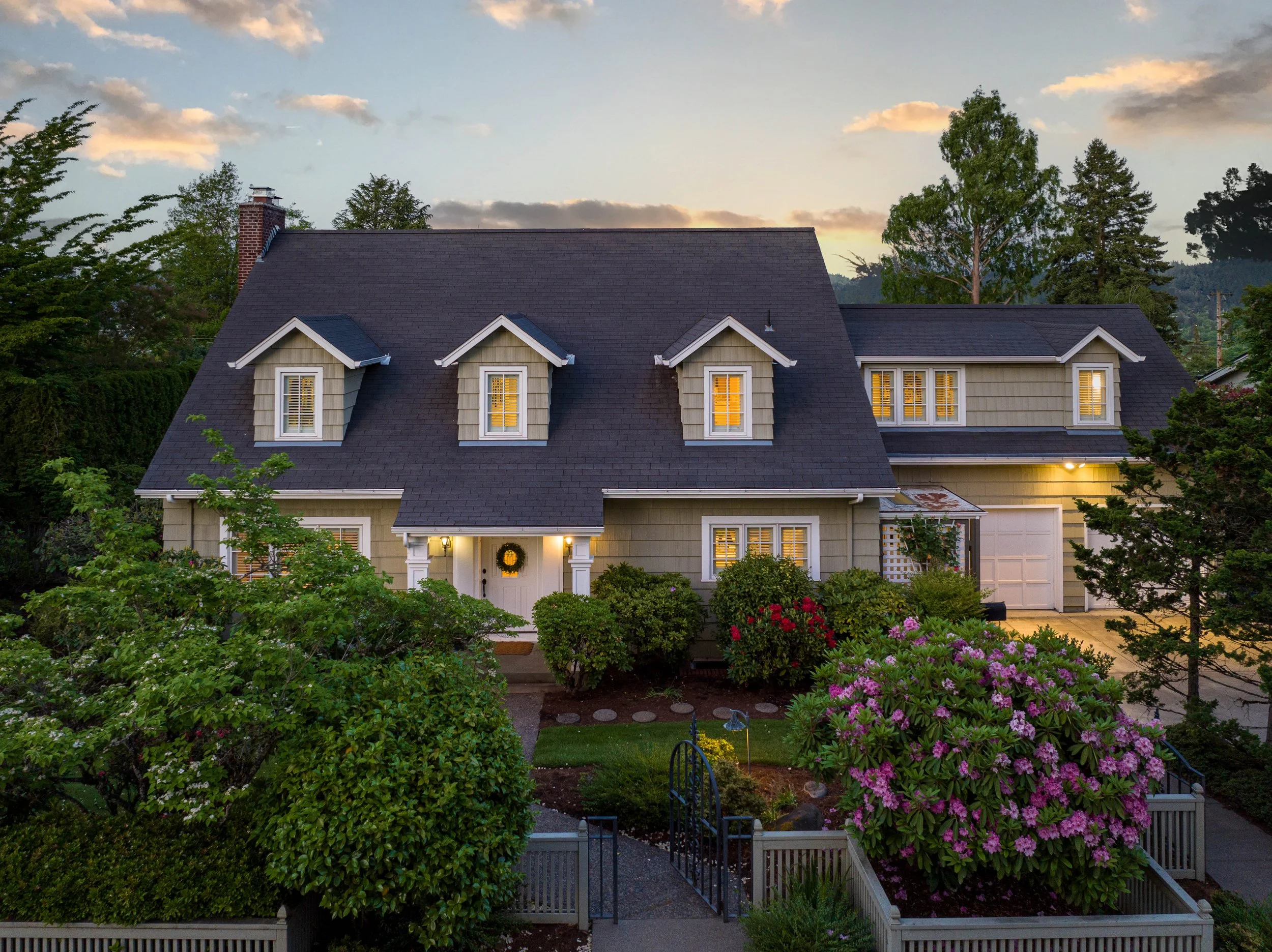 Twilight aerial view of a Pacific Northwest estate with pool and mature trees