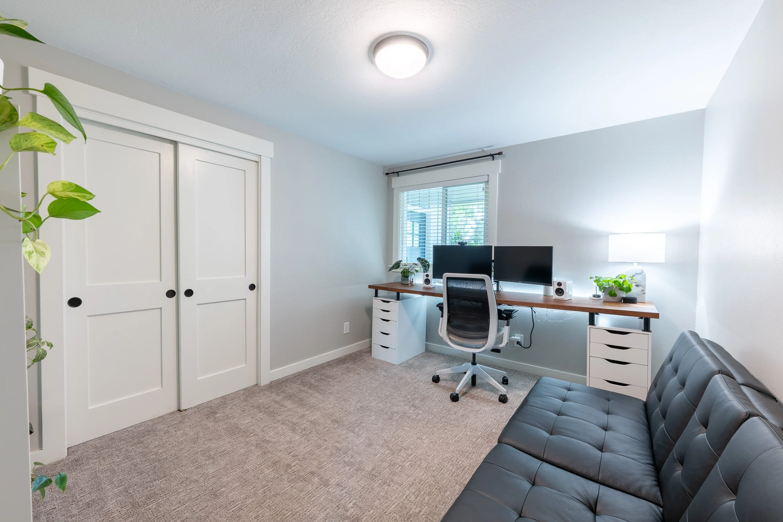 Home office with desk, computer setup, and built-in closet storage