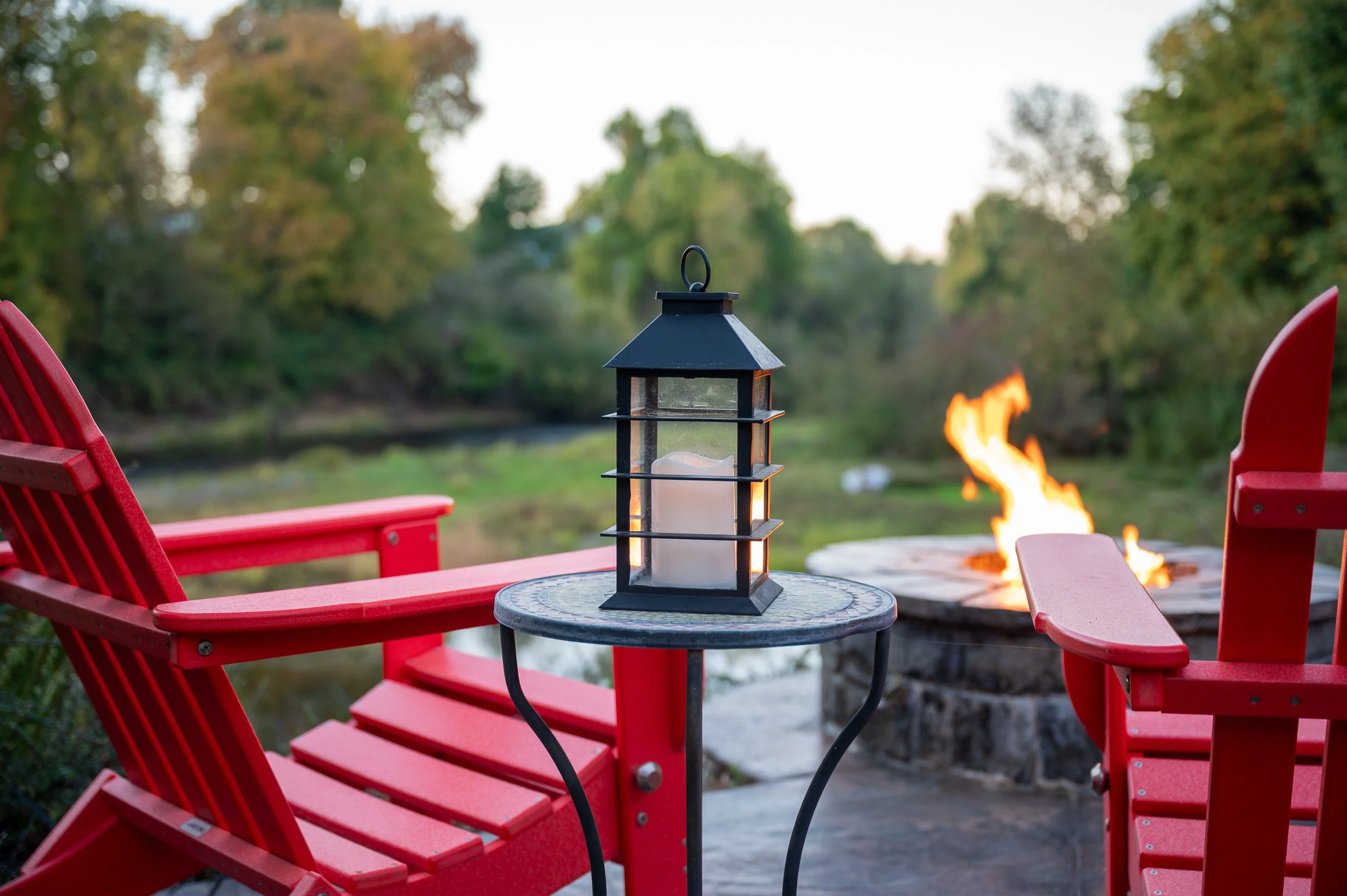 Detail photo of a pair of red chairs on a deck facing a fire pit and a landscape view in portland, Oregon
