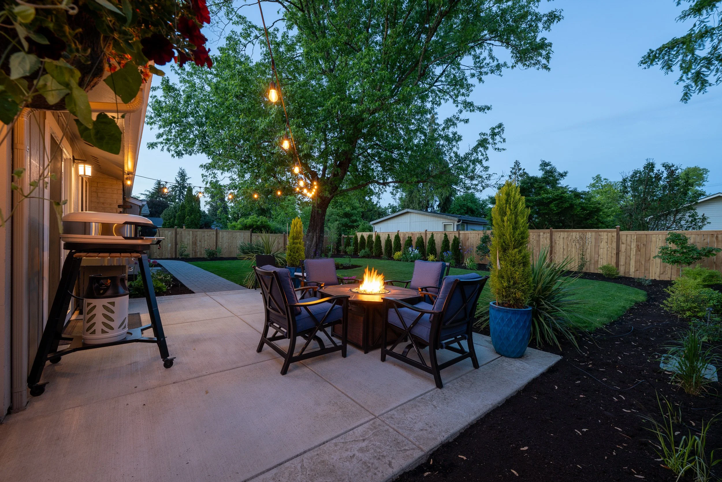 Outdoor dining area with table, string lights, and evening ambiance
