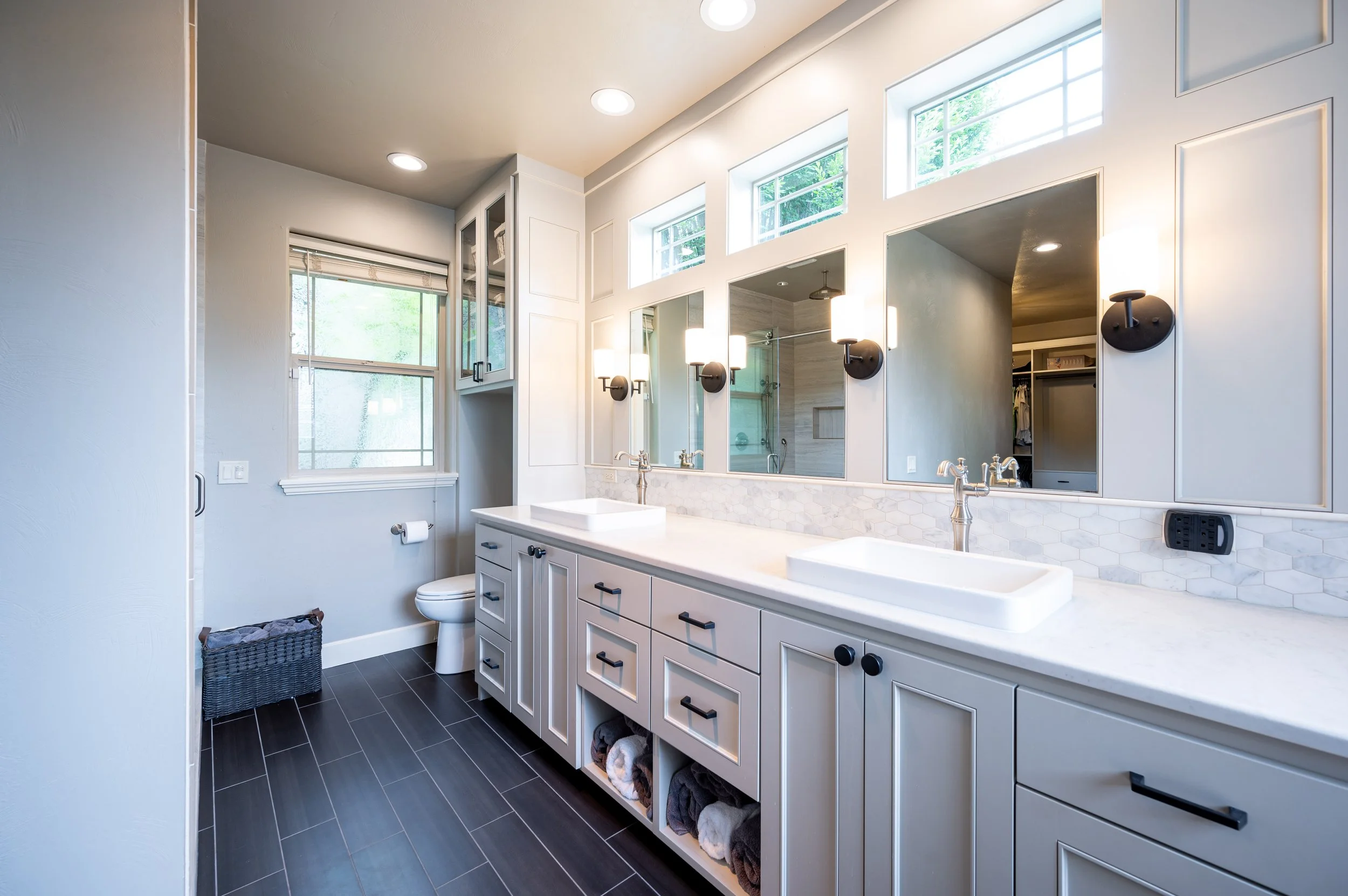 Primary bathroom with double vanity, large mirror, and tiled flooring