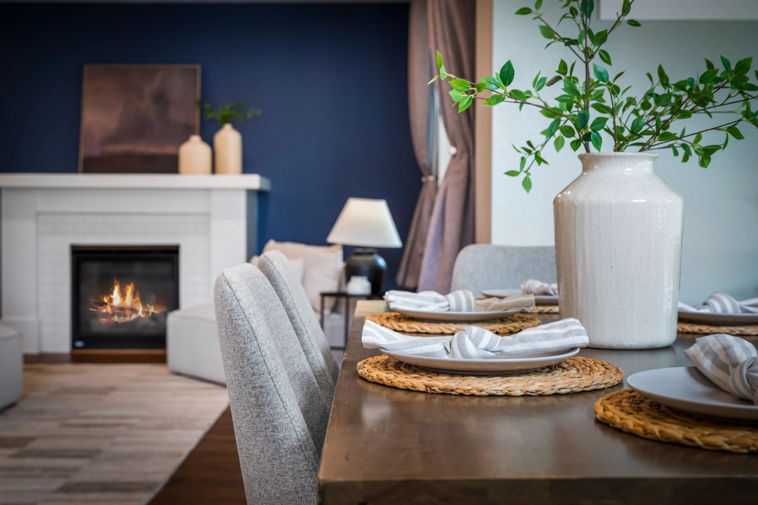 Detail shot of a staged dining table with a fireplace in the background