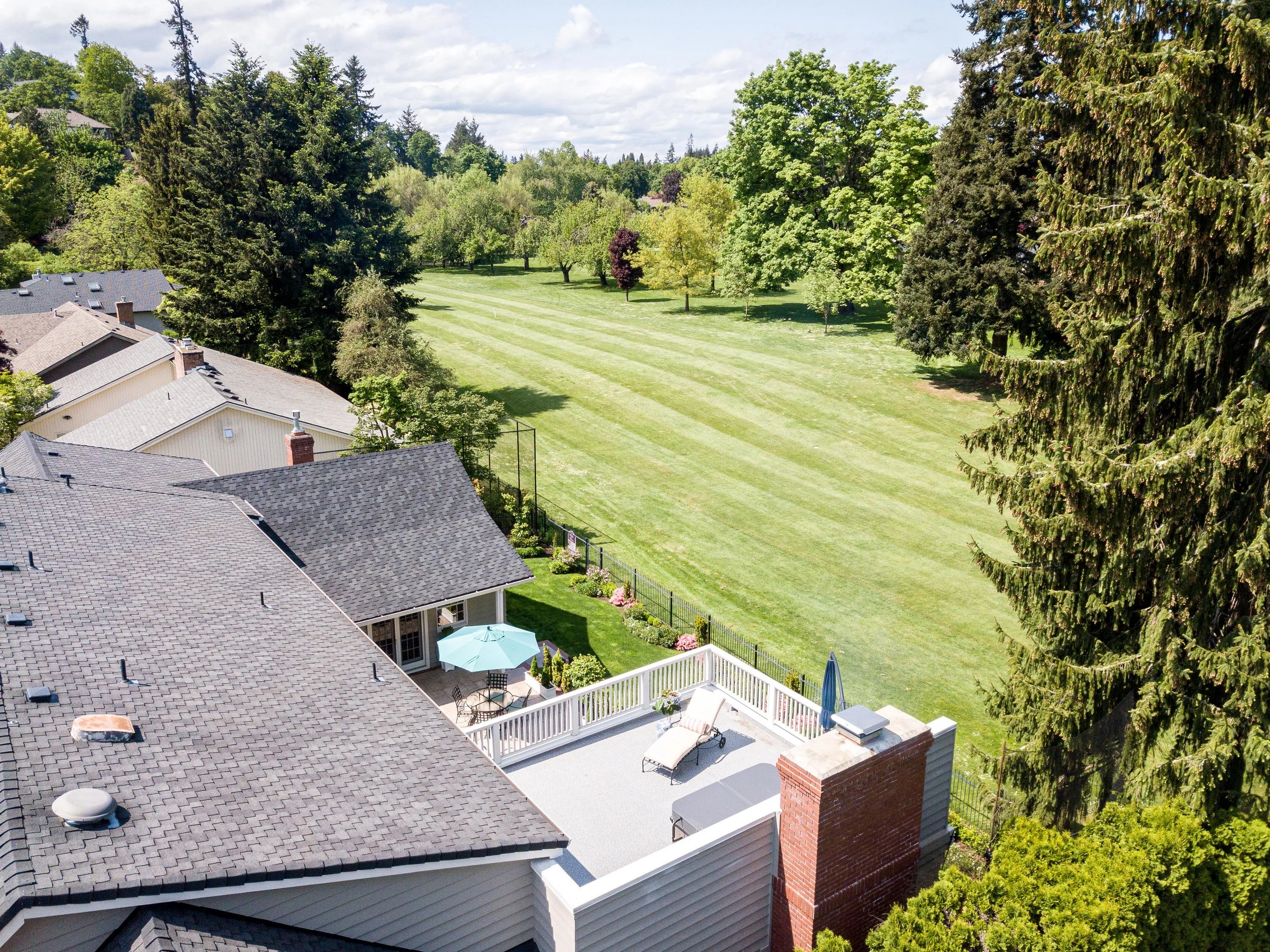 Backyard patio and deck with outdoor seating and landscaped lawn