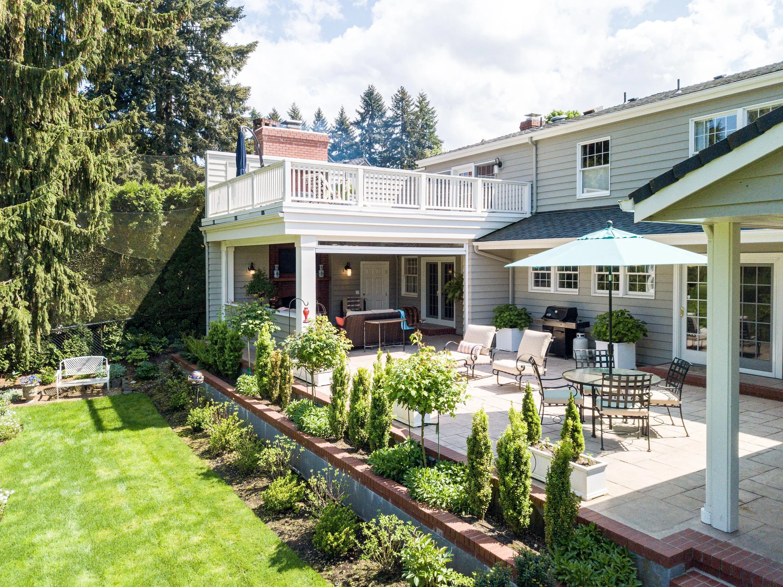 Backyard patio and deck with outdoor seating and landscaped lawn