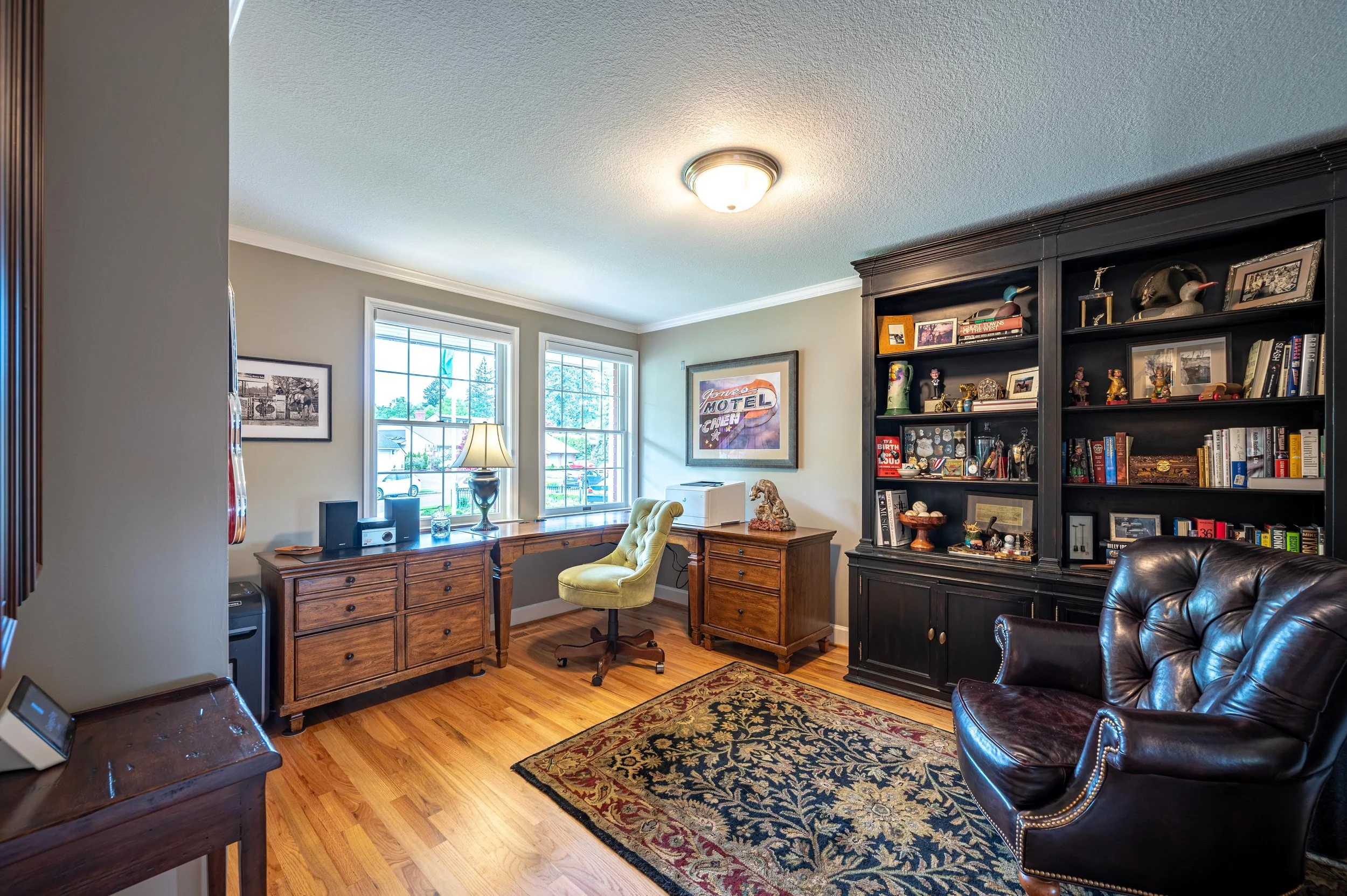 Home office with built-in shelving, hardwood floors, and natural light