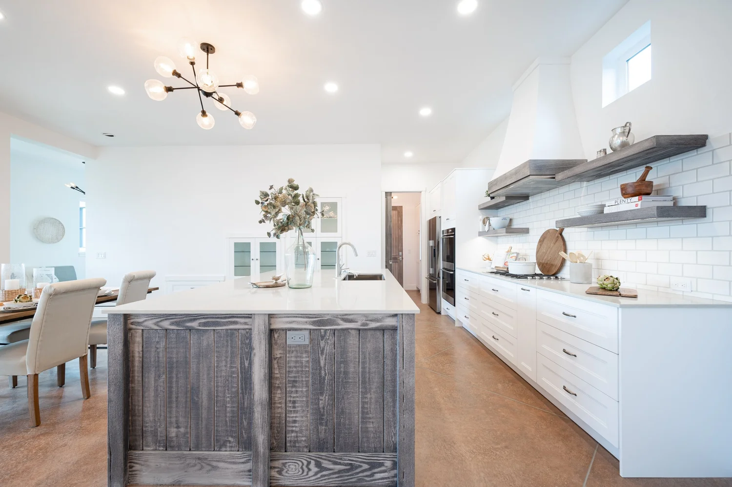 Bright modern farmhouse kitchen with white cabinetry, wood island, and open-concept layout