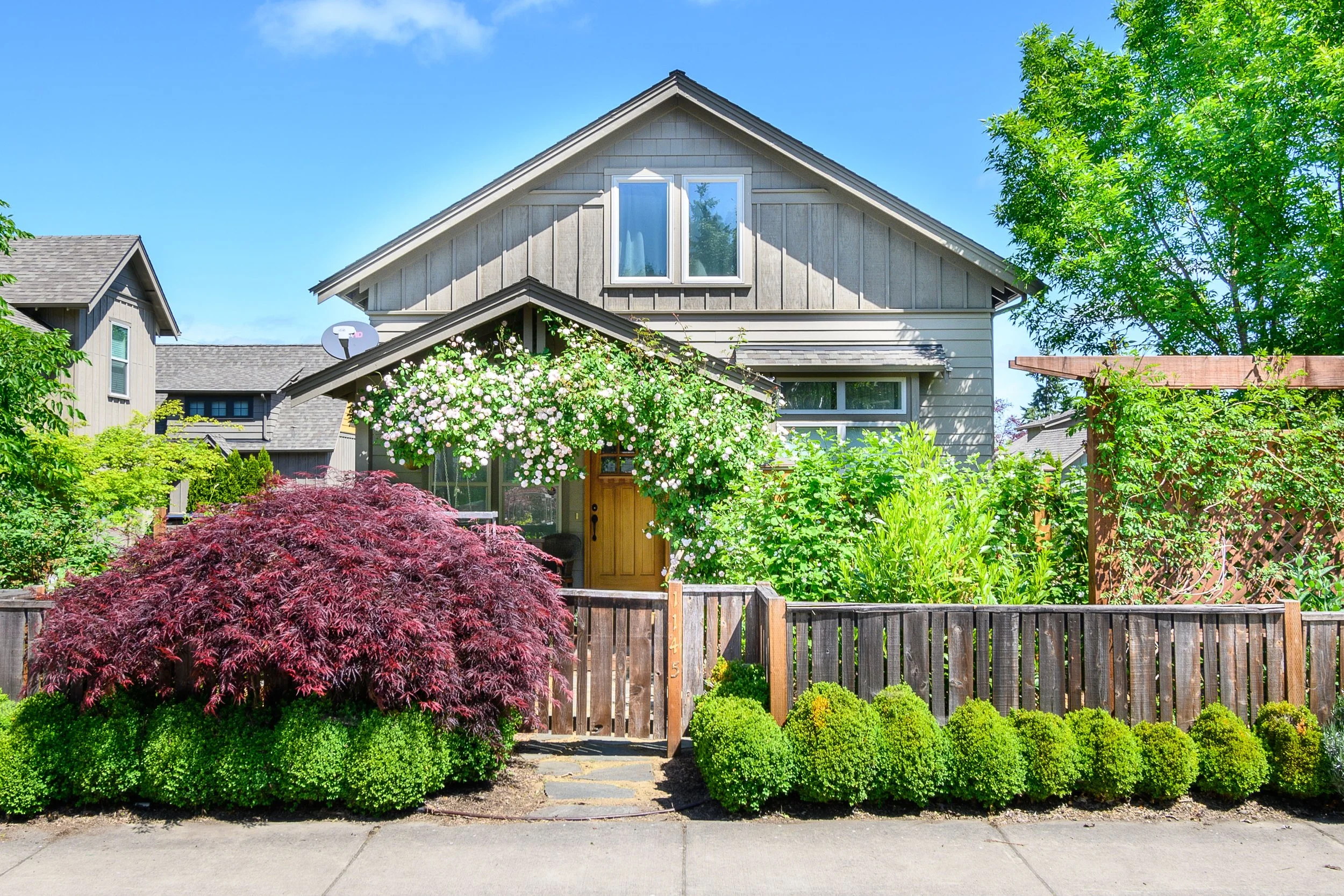 Front exterior of a craftsman-style home with covered porch and flowering vines