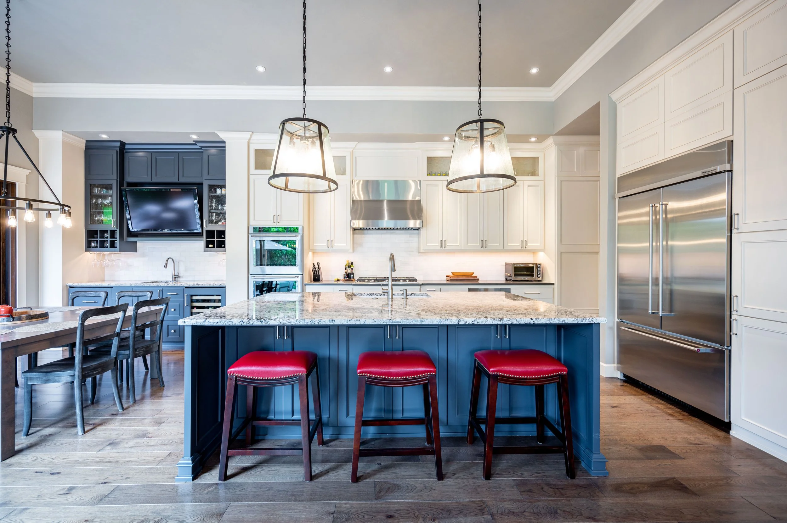 Modern kitchen with blue island, pendant lighting, and bar seating