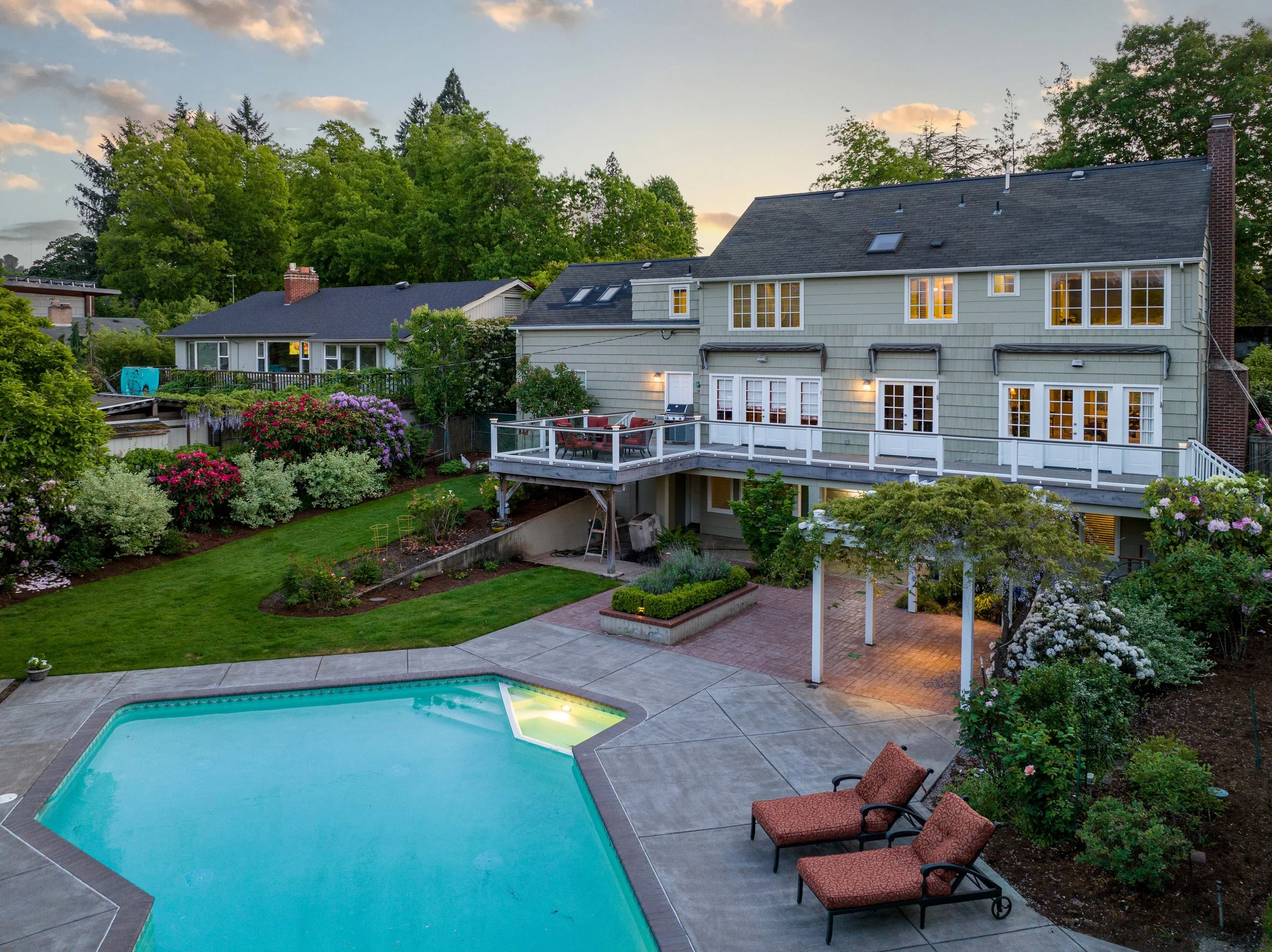 Twilight photo of a traditional home in portland featuring a backyard with an upper deck and pool