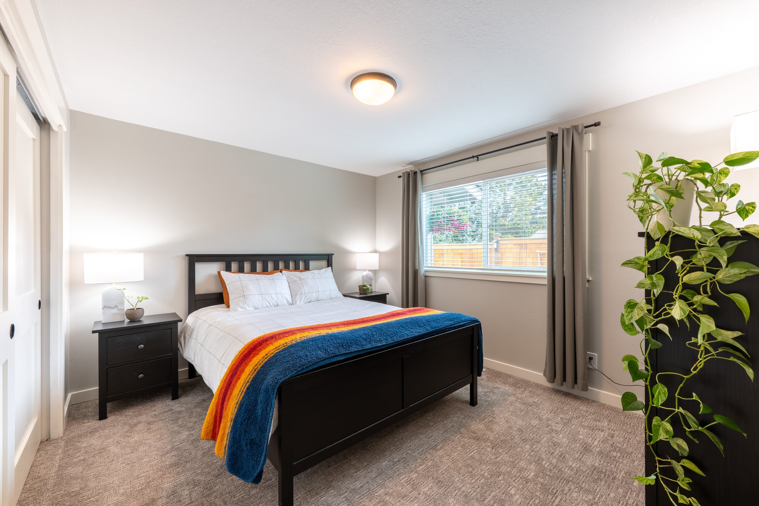 Bedroom with centered bed, window, and soft neutral finishes