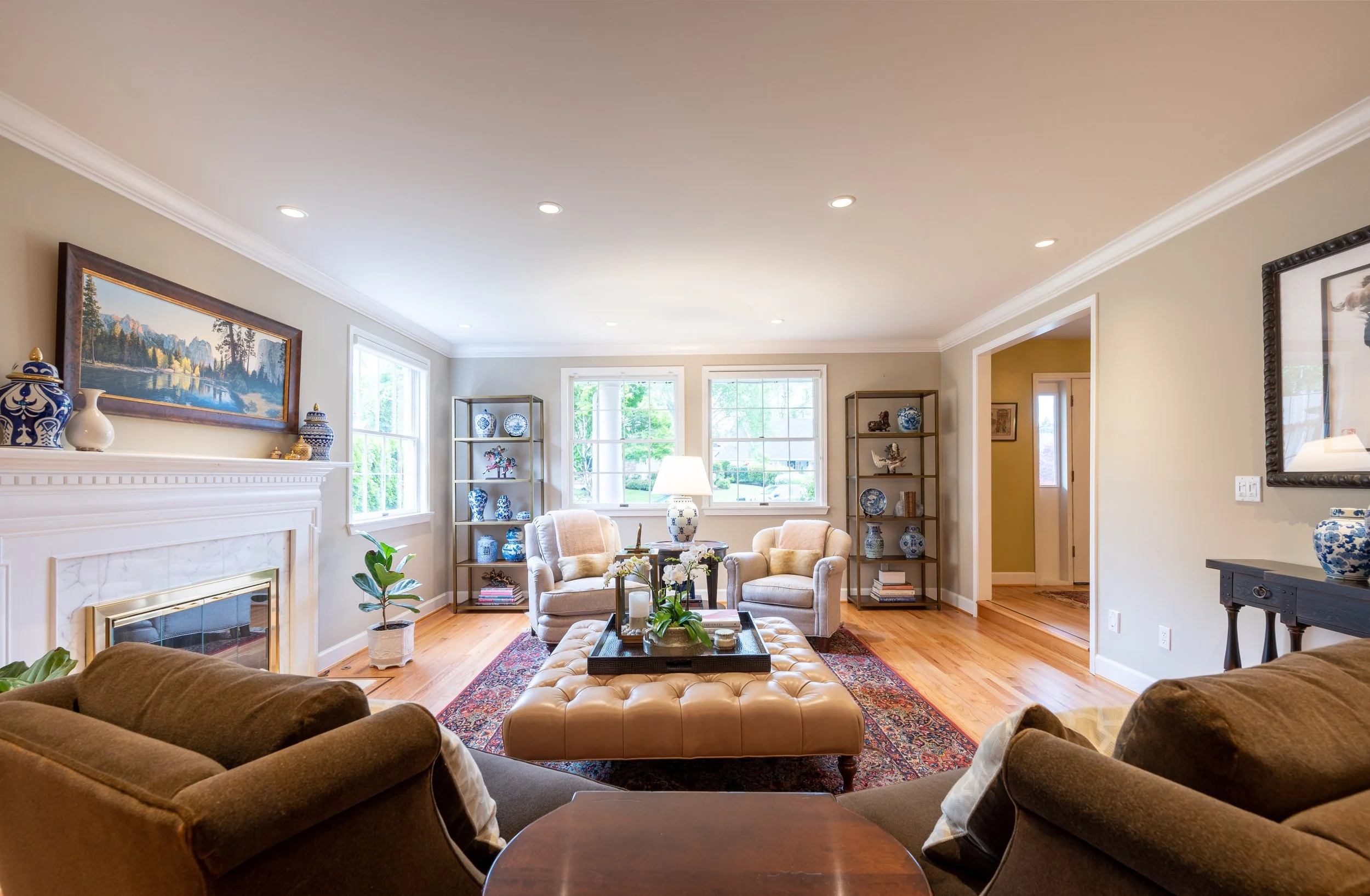 Living room with fireplace, layered seating, and warm natural light