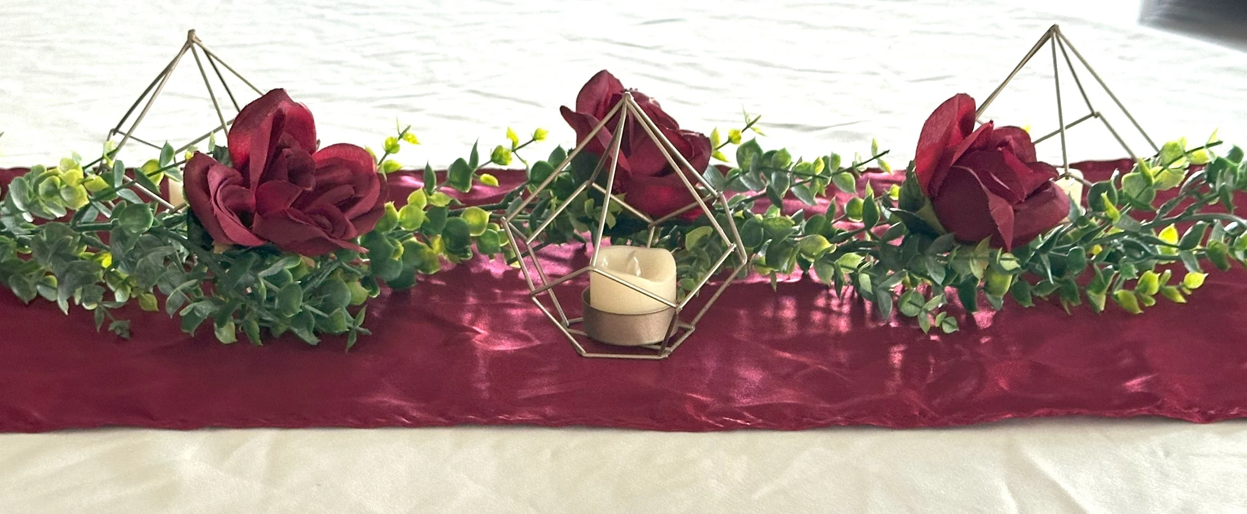 Burgundy, gold, and greenery were the colors this couple opted for. The geometric shapes were perfect to keep the centerpieces low so visiting across the table was easier.
