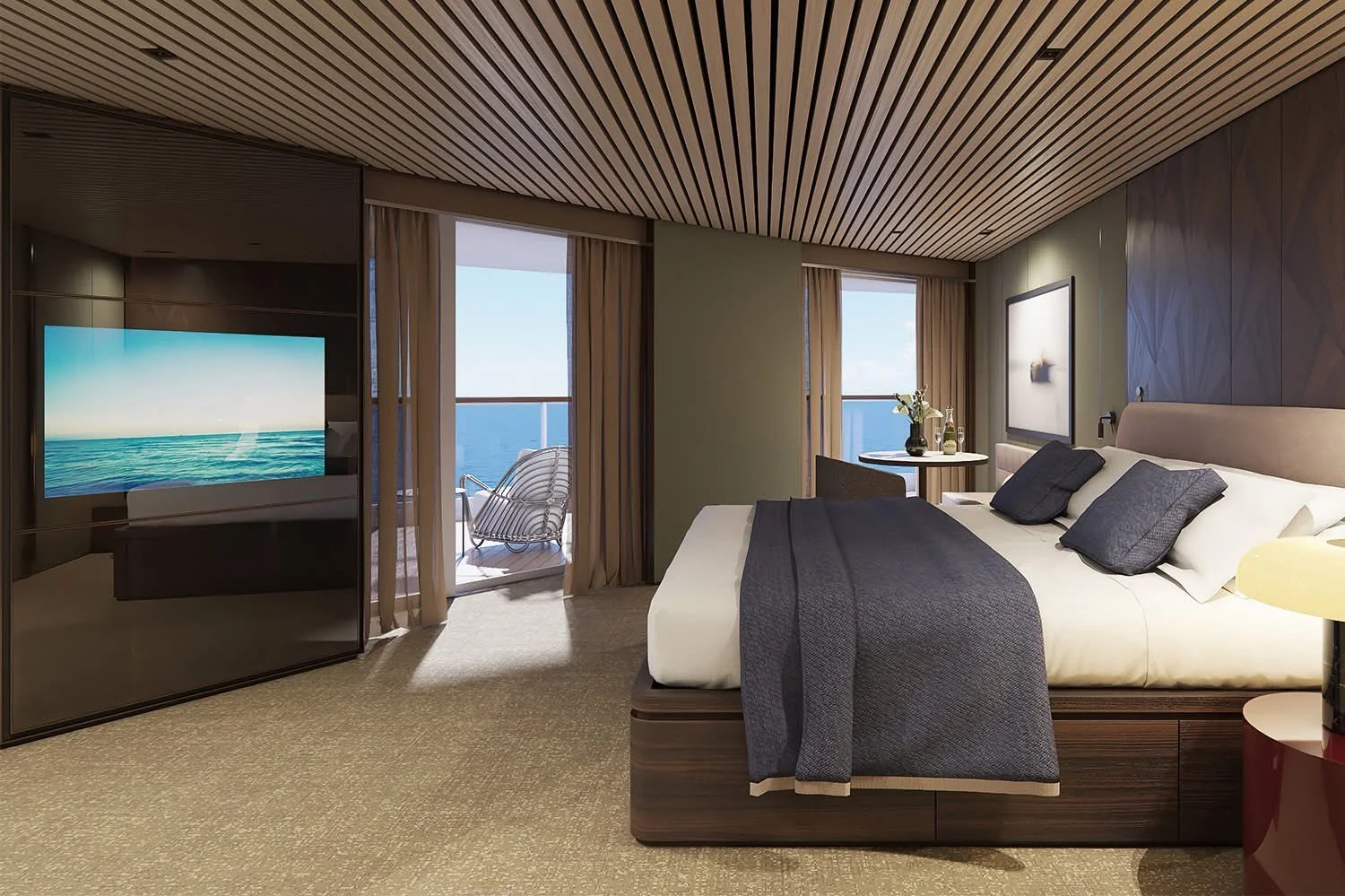 Modern bedroom with ocean view, large bed with dark pillows and blanket, sliding glass door leading to a balcony with ocean view, flat screen TV, framed artwork, small round table with decorative items, beige carpet and wooden ceiling.