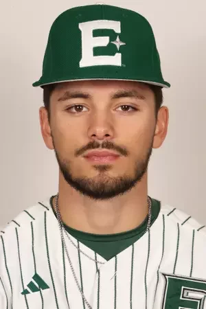 Close-up of a young man wearing a green baseball cap with a white letter E and star, and a white baseball jersey with green pinstripes and a Nike logo.