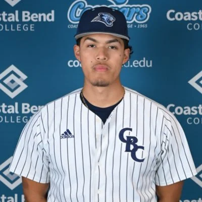 Young man wearing a baseball cap and a striped baseball jersey with 'GRC' logo, standing in front of a Coastal Bend College backdrop.