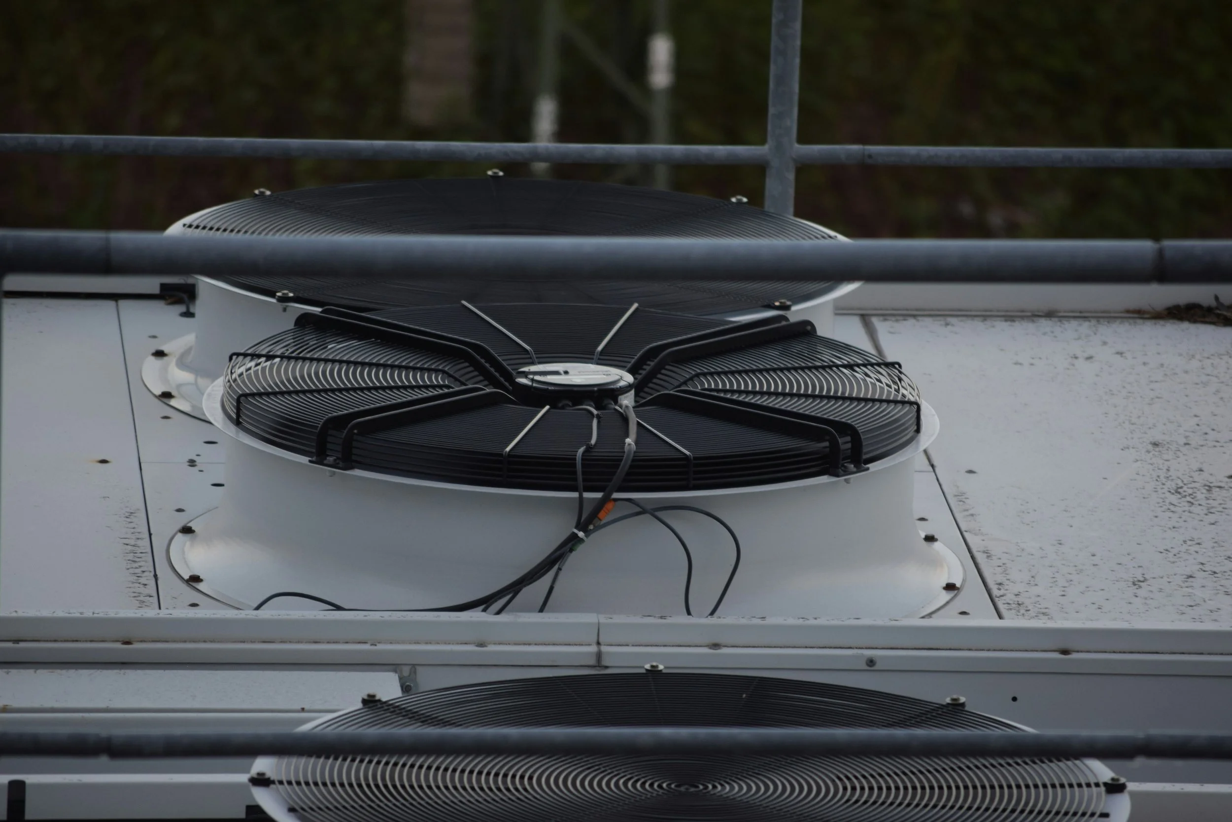Close-up of air conditioning unit fans on a rooftop.