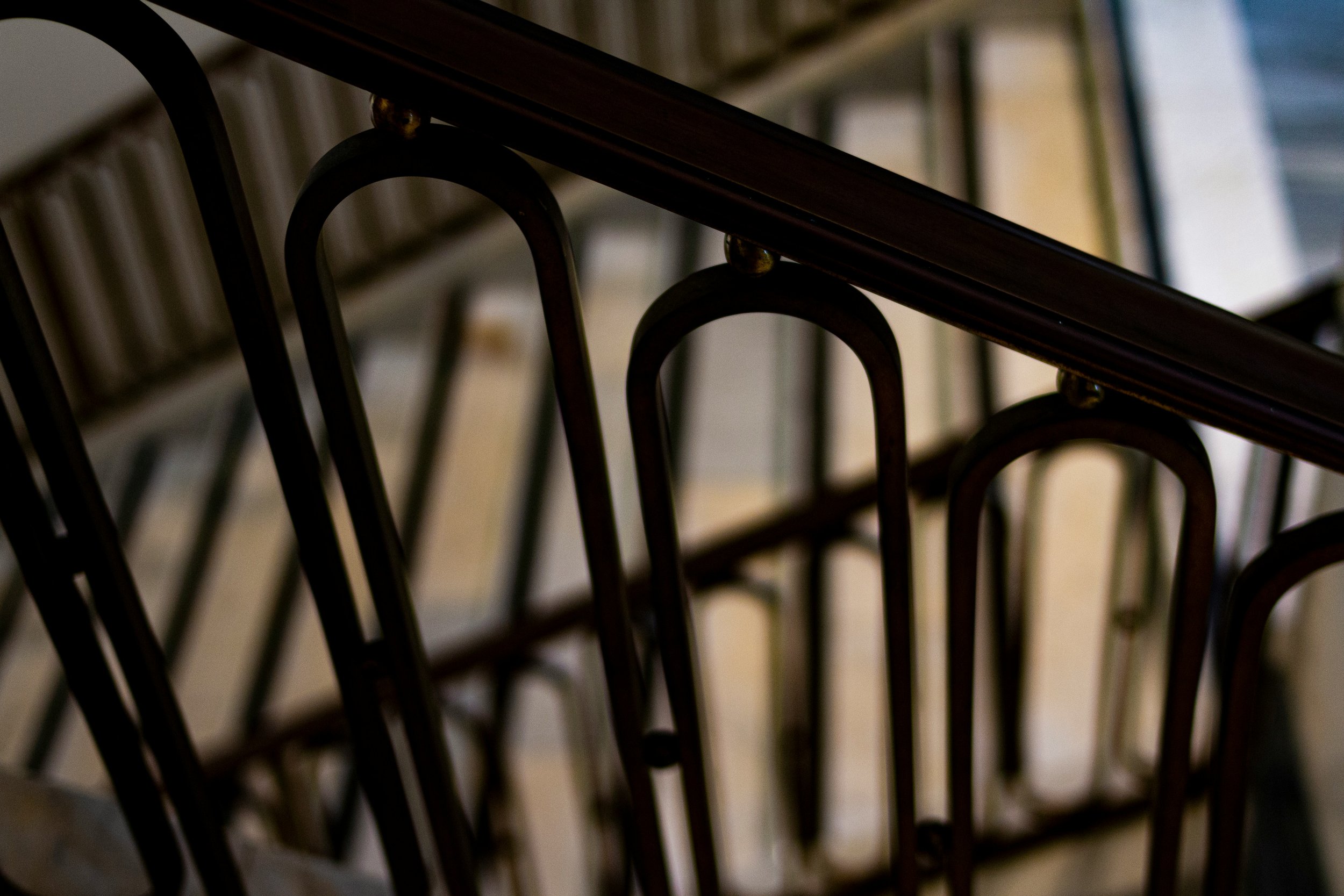 Close-up view of a stack of black metal folding chairs with curved backs, seen from above.