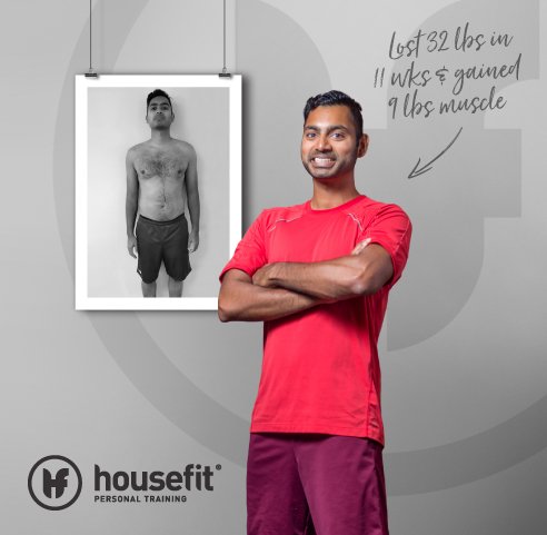 A man in a red shirt and purple shorts smiling with arms crossed, standing next to a framed black-and-white photo of his before weight loss. Handwritten note on wall indicates he lost 32 pounds, gained 9 pounds of muscle through personal training.