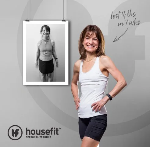 Smiling woman in workout clothes marking her weight loss progress, with a before photo and handwritten notes on a wall.