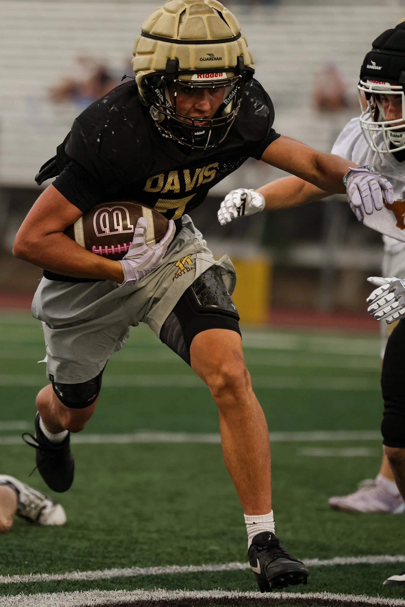 Running back carries the ball in a scrimmage.
