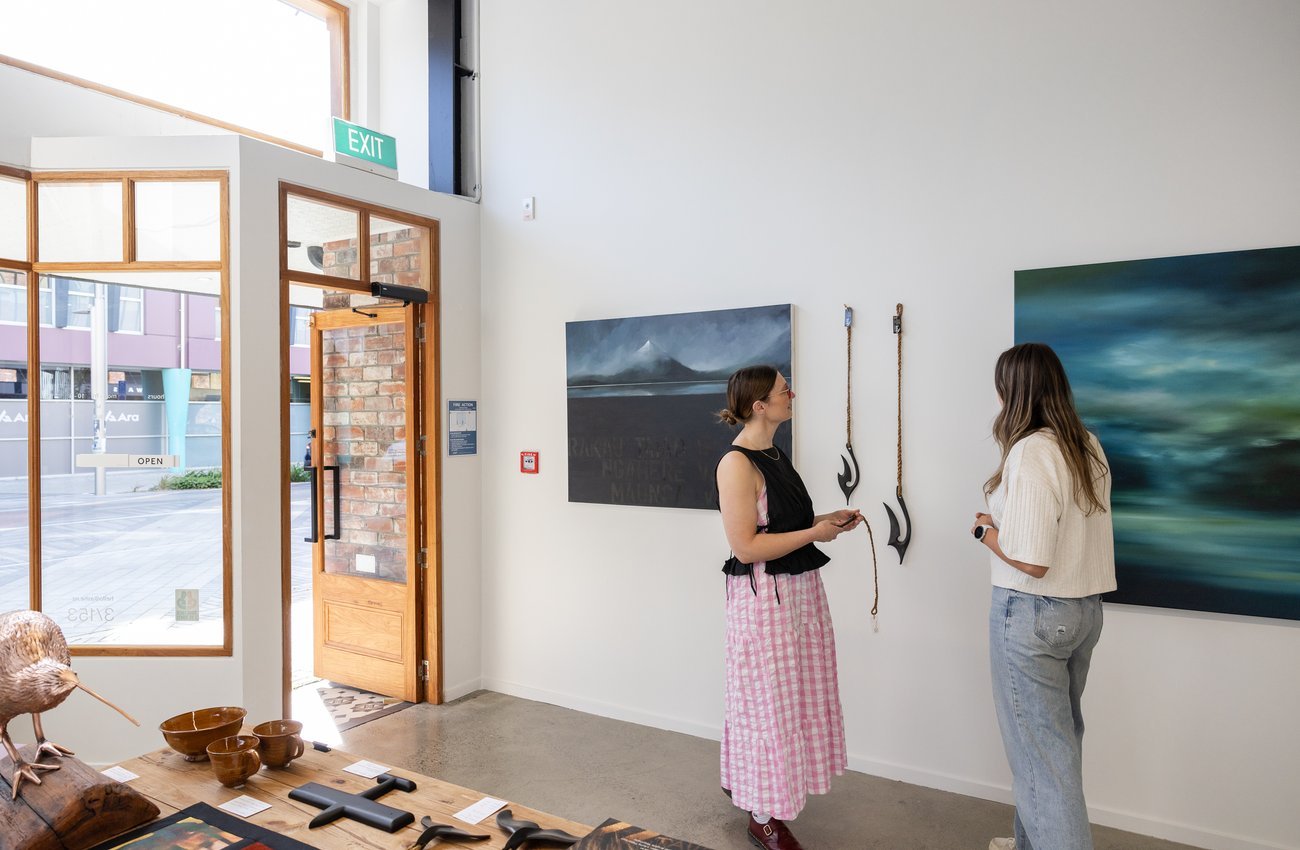Ashleigh assisting a client to purchase a new art piece