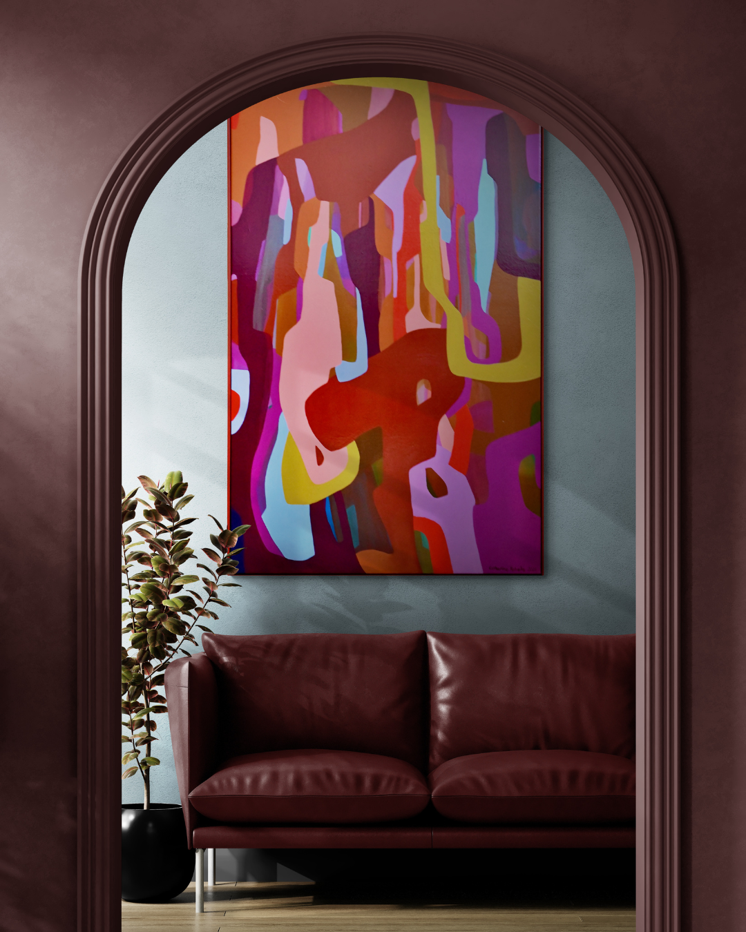 Interior view with a burgundy leather sofa, potted plant, and colorful abstract painting on the wall, framed by a dark arched doorway.