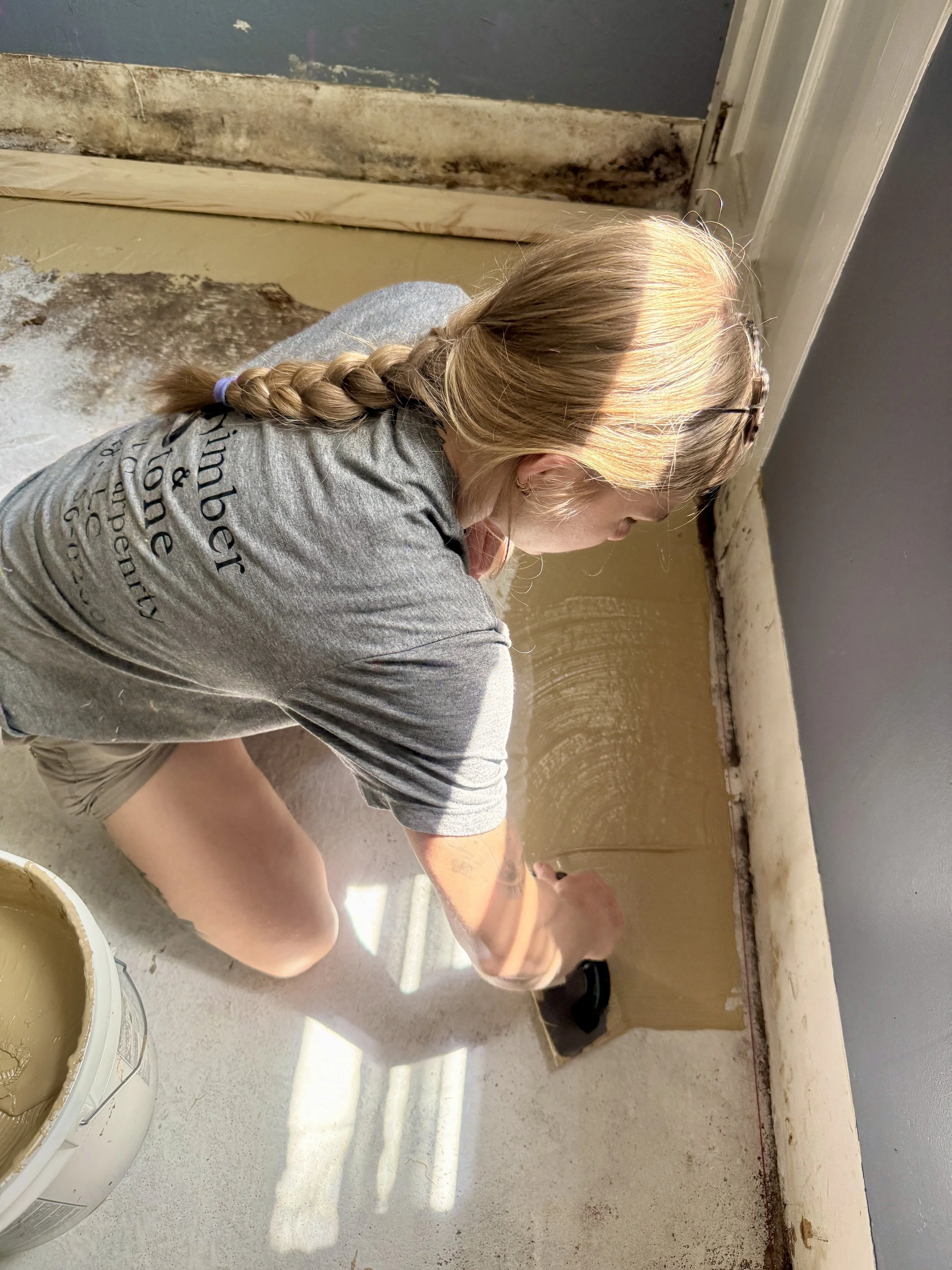 Owner Ryanna laying a wood floor