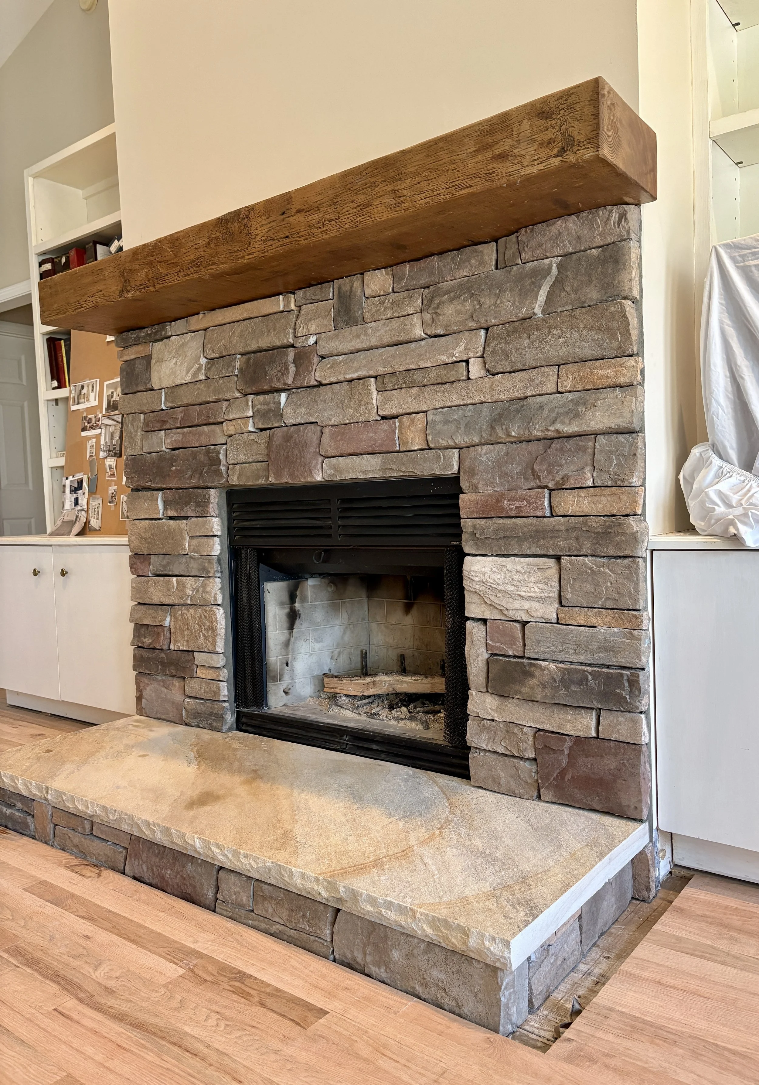 A stone fireplace and hearth built by Timber and Stone