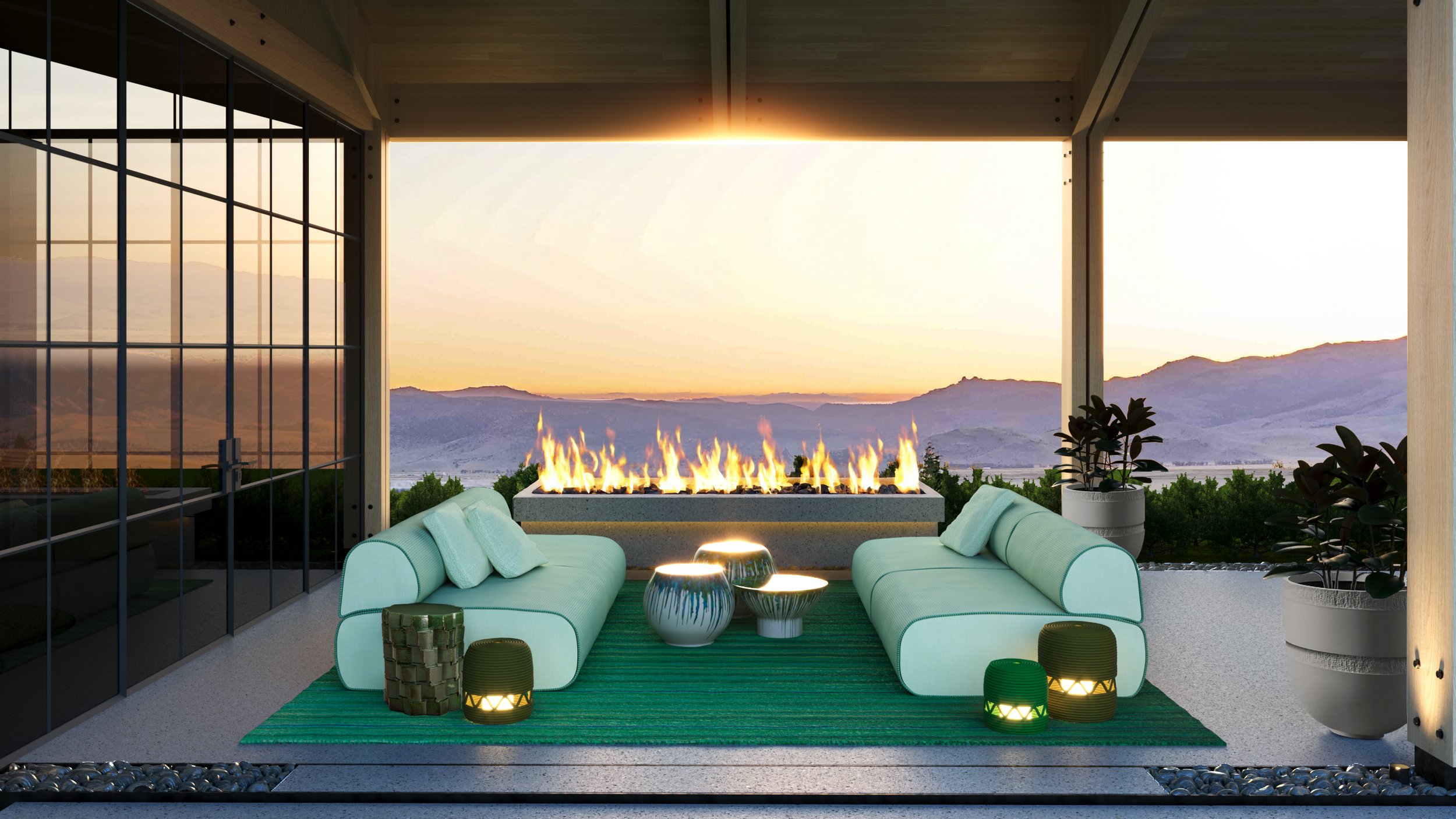 Modern outdoor living space with turquoise couches, small tables, potted plants, and a fire feature overlooking a mountain landscape at sunset.