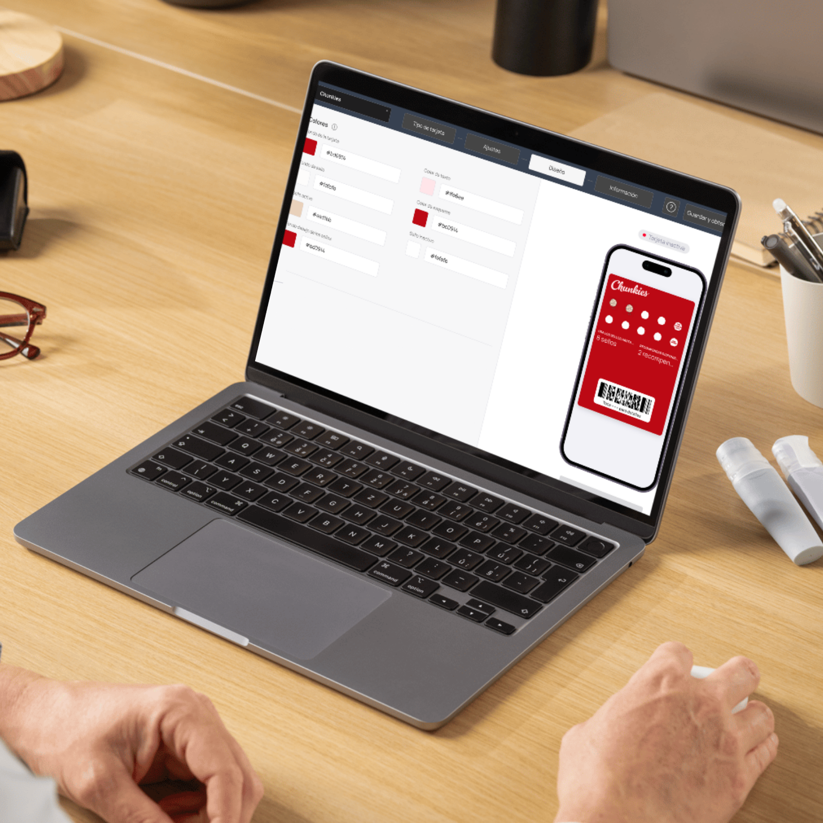 Persona trabajando en una computadora portátil con un diseño de tarjeta de fidelización digital de ejemplo en la pantalla.