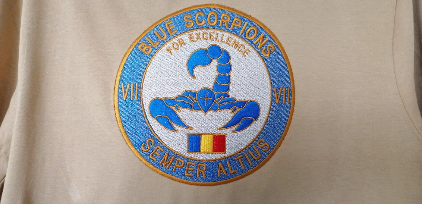 Zbliżenie haftu Blue Scorpions z niebieskim skorpionem, rumuńską flagą i napisami na koszulce