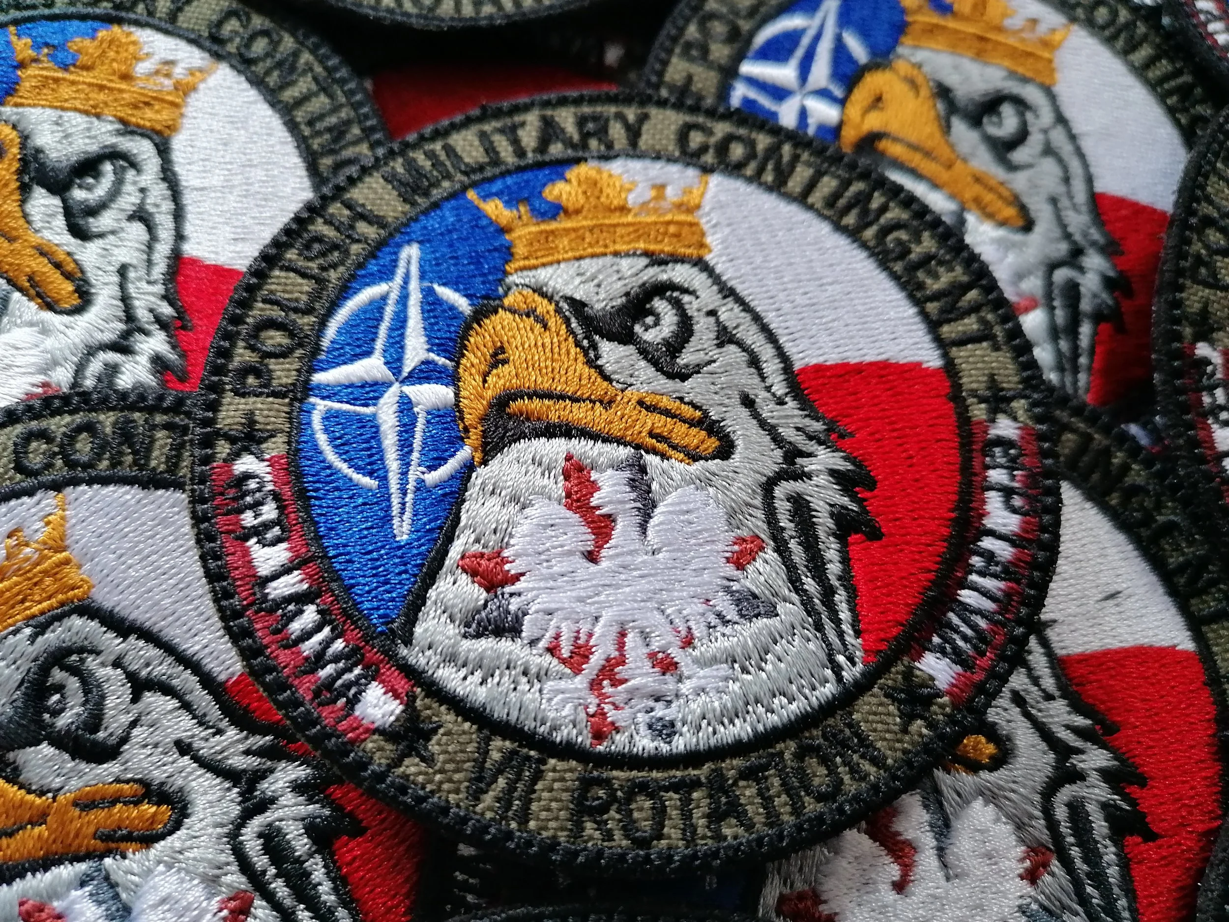 Haftowane naszywki Polskiego Kontyngentu Wojskowego na Łotwie z orłem, flagą Polski i symbolem NATO